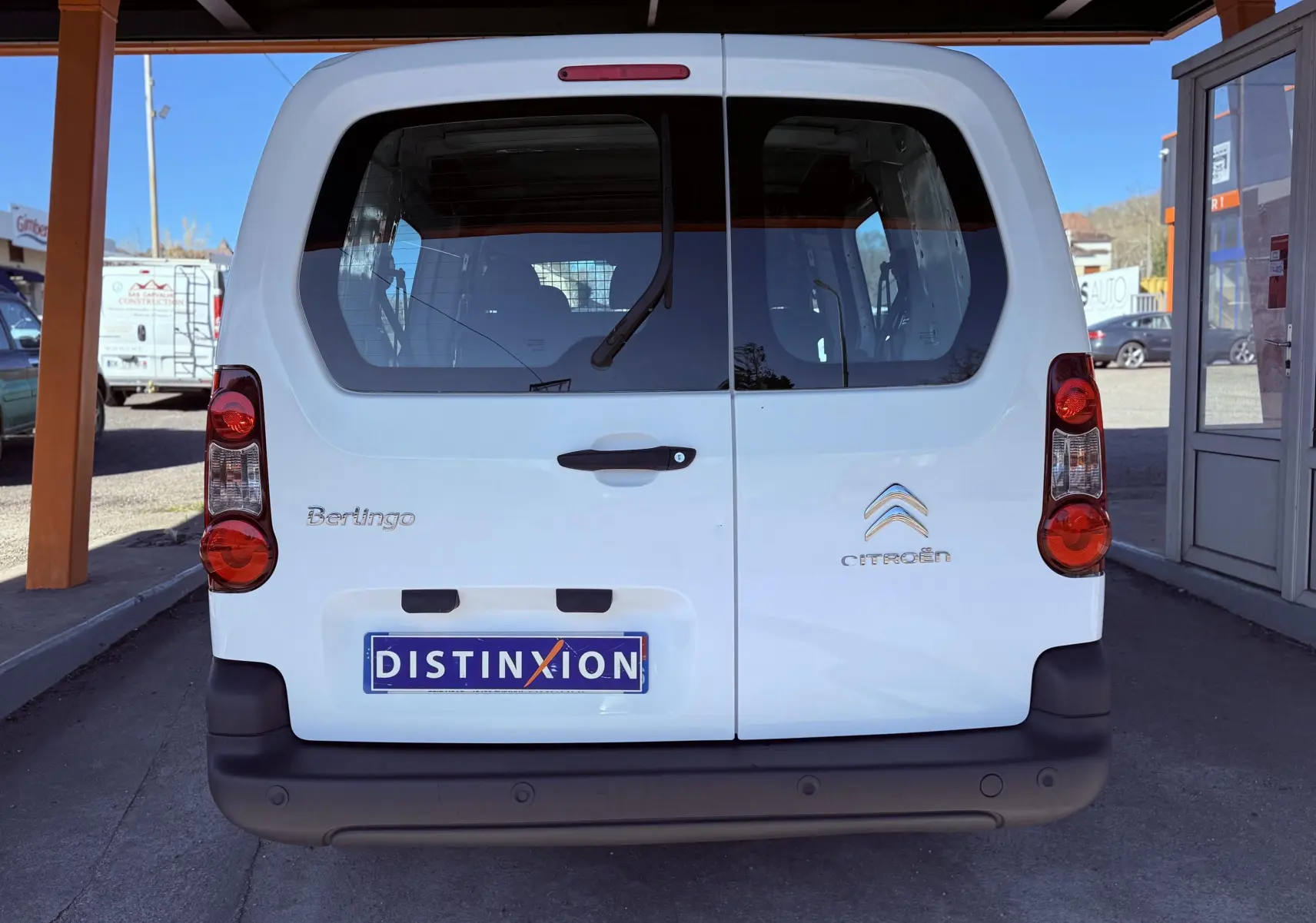 Vue arrière d’un Citroën Berlingo blanc 2017 avec hayon double portes et logo distinctif sur parking couvert.