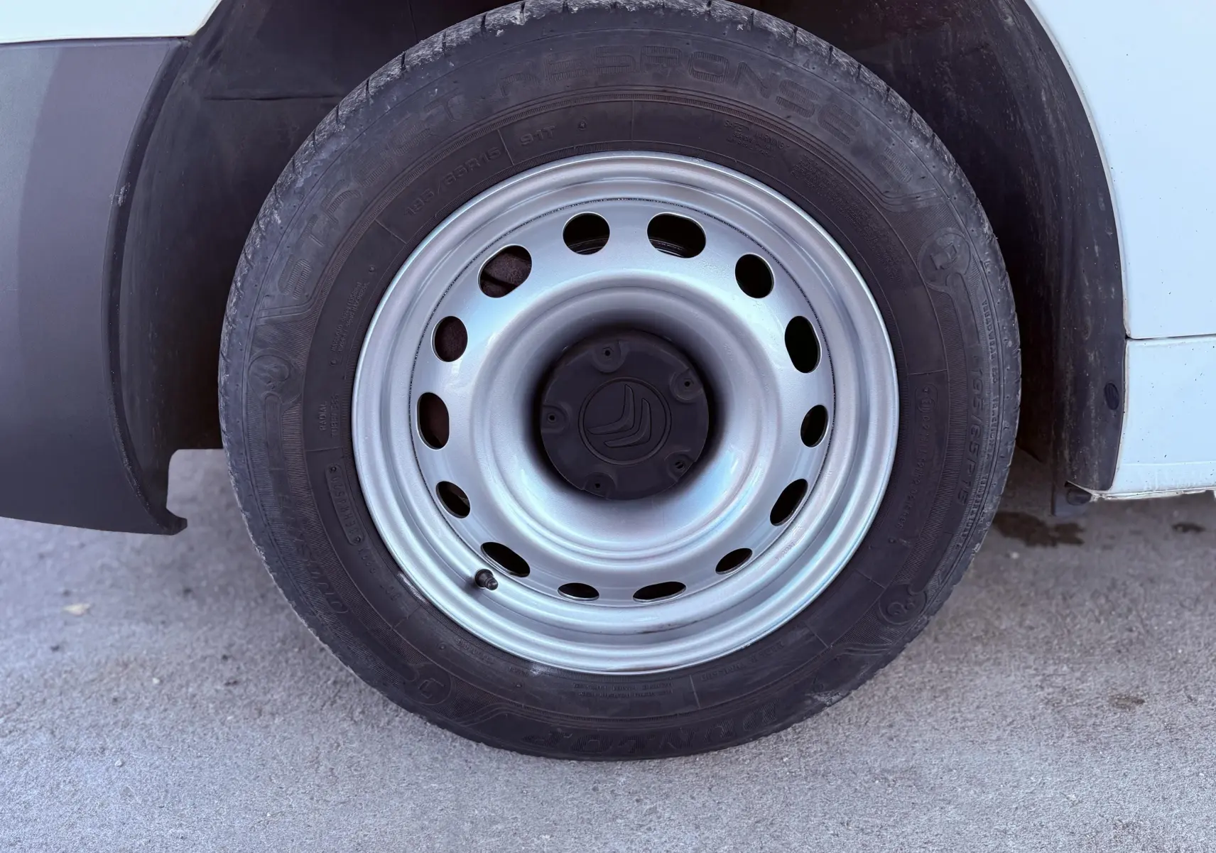 Gros plan sur la roue avant droite avec jante acier argentée du Citroën Berlingo blanc de 2017.