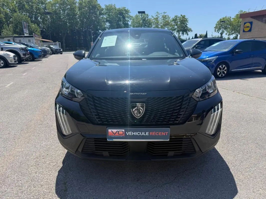 Vue frontale d'un Peugeot 2008 Hybrid noir 2025 avec calandre noire et feux LED verticaux distinctifs.
