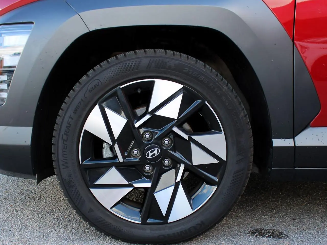 Gros plan sur la roue avant droite du Hyundai Kona rouge Ultimate Metal avec jante alliage noire et argentée.