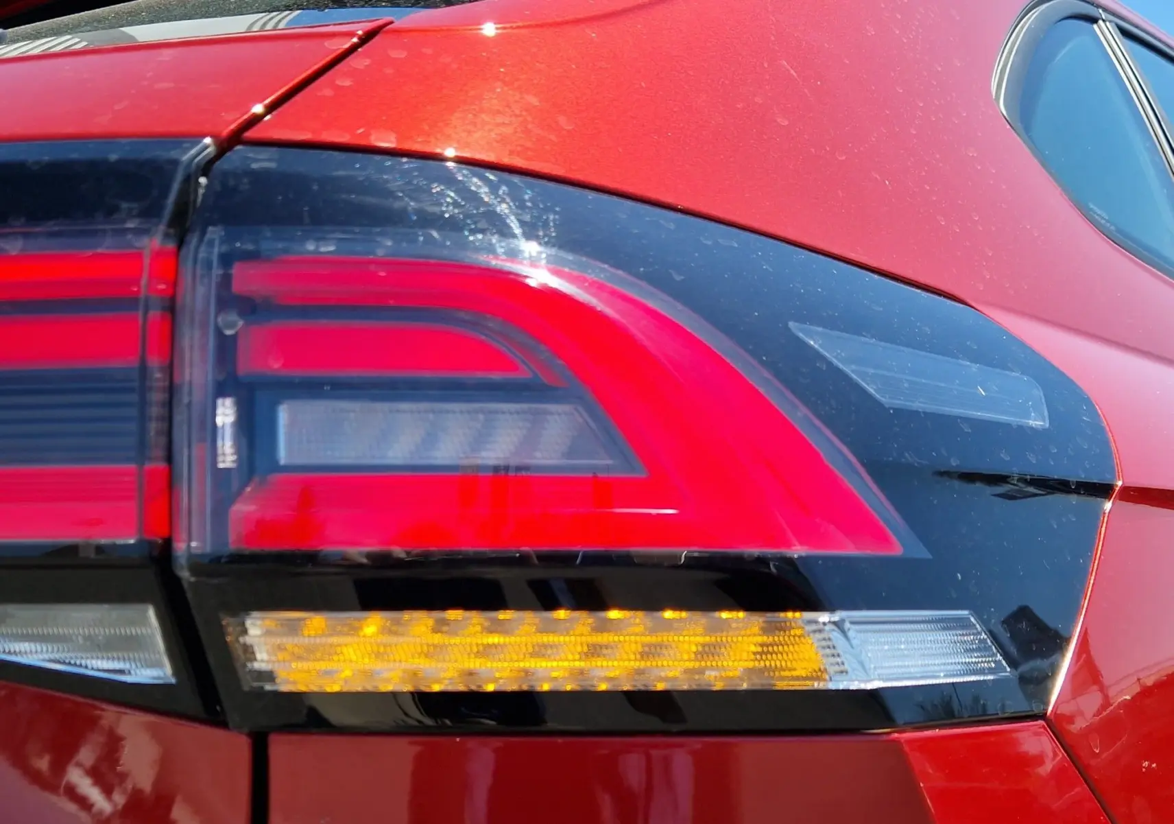 Gros plan sur le feu arrière droit rouge et noir du Volkswagen Taigo rouge roi 2023, soulignant son design moderne.