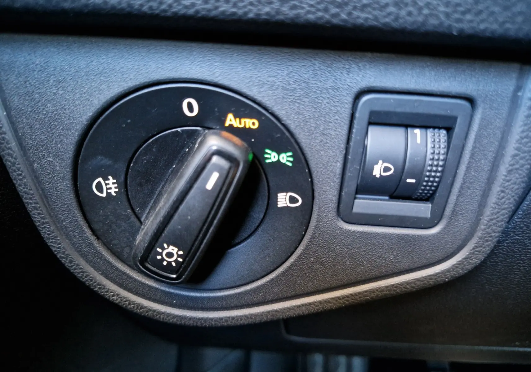 Gros plan sur le bouton de commande des phares du Volkswagen Taigo 2023, avec réglage automatique activé.