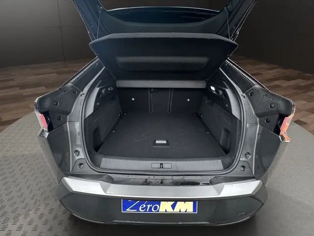 Coffre ouvert en vue arrière du Peugeot 3008 gris titane 2025, montrant l'espace de chargement et les feux arrière LED.