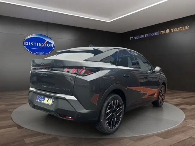 Vue 3/4 arrière droite du Peugeot 3008 gris titane avec feux LED et jantes noires bicolores en showroom