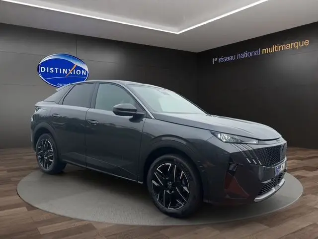 Peugeot 3008 gris titane en 3/4 avant droit, avec jantes noires et phares LED dans un showroom.