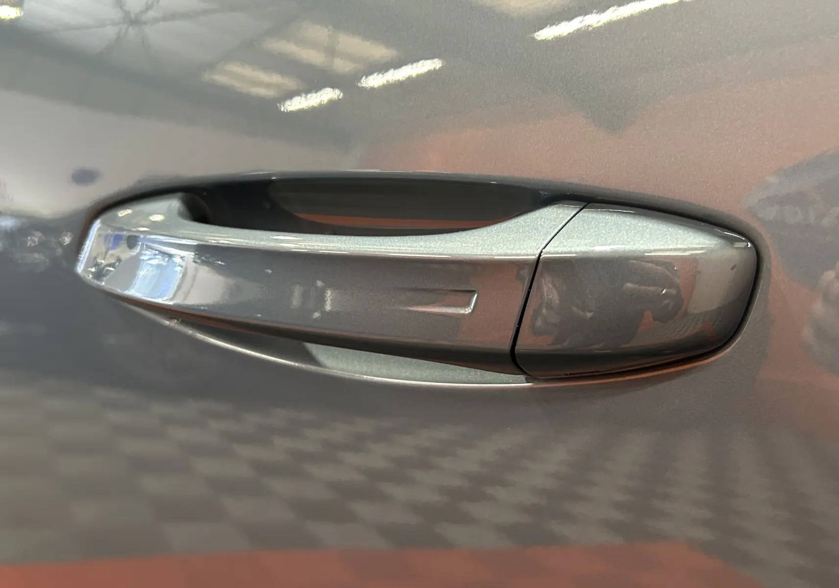 Poignée de porte côté droit en gros plan sur Peugeot 5008 bleu Ingaro avec finition lisse et reflet intérieur.