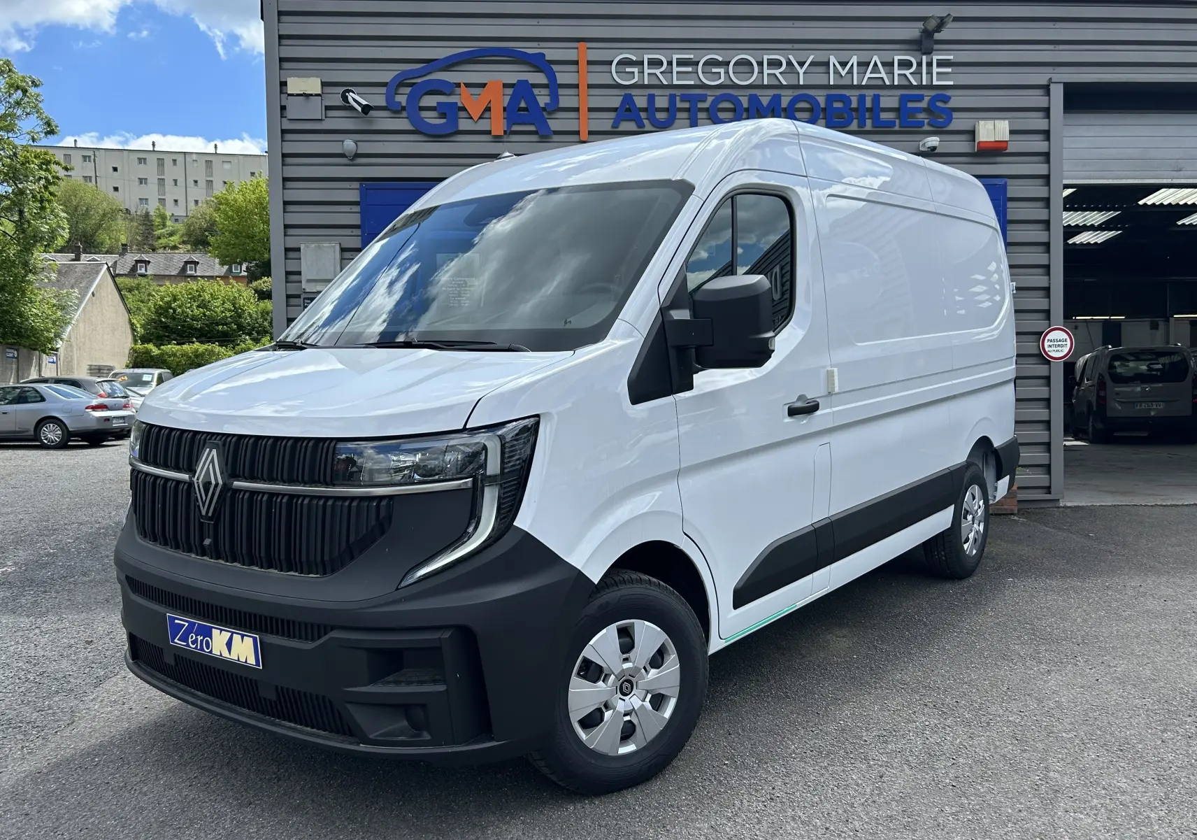 Renault Master blanc en vue 3/4 avant droit, fourgon utilitaire garé devant un garage Gregory Marie Automobiles.