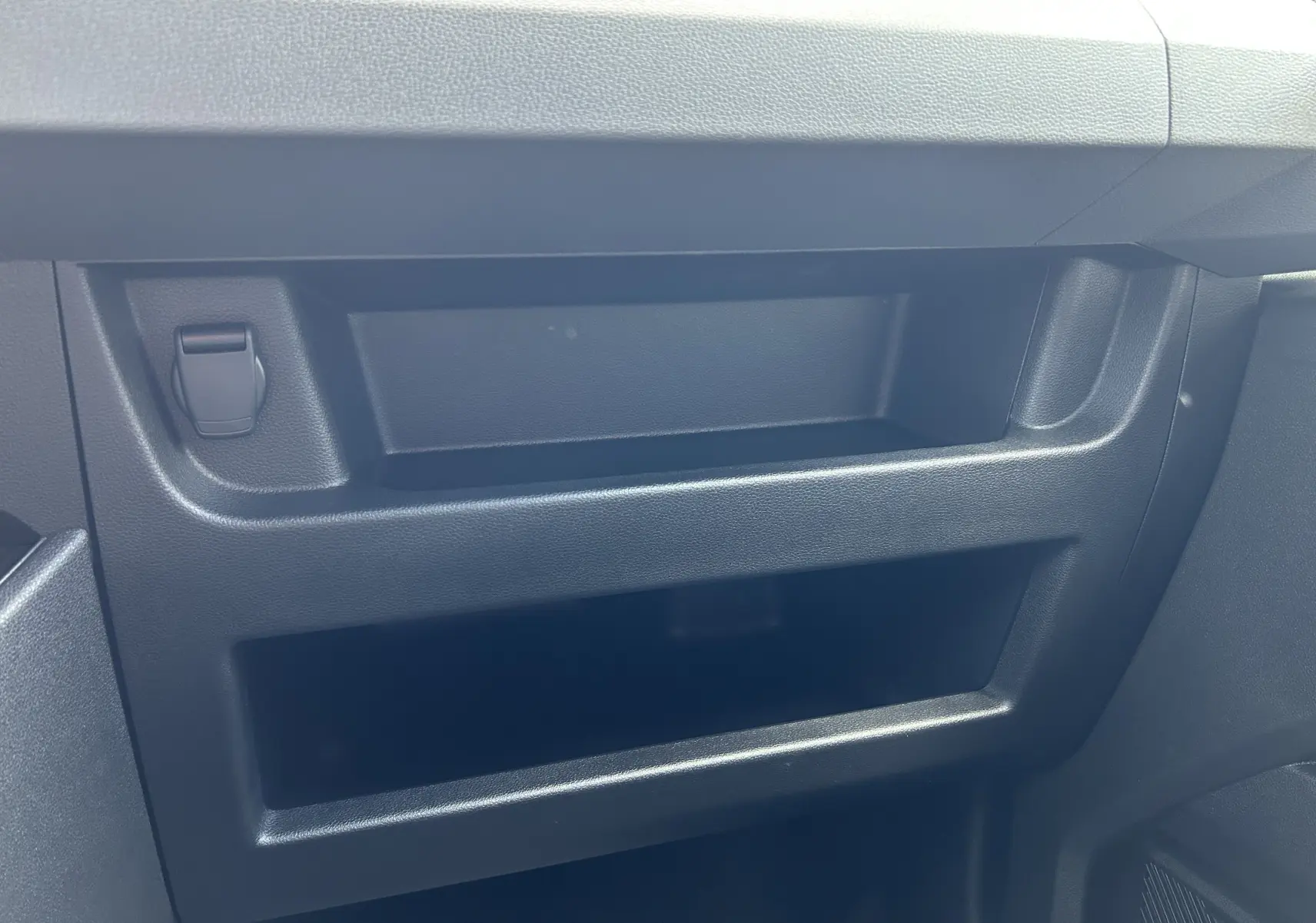 Détail du rangement en plastique noir sur la planche de bord côté passager du Renault Master blanc 2025.