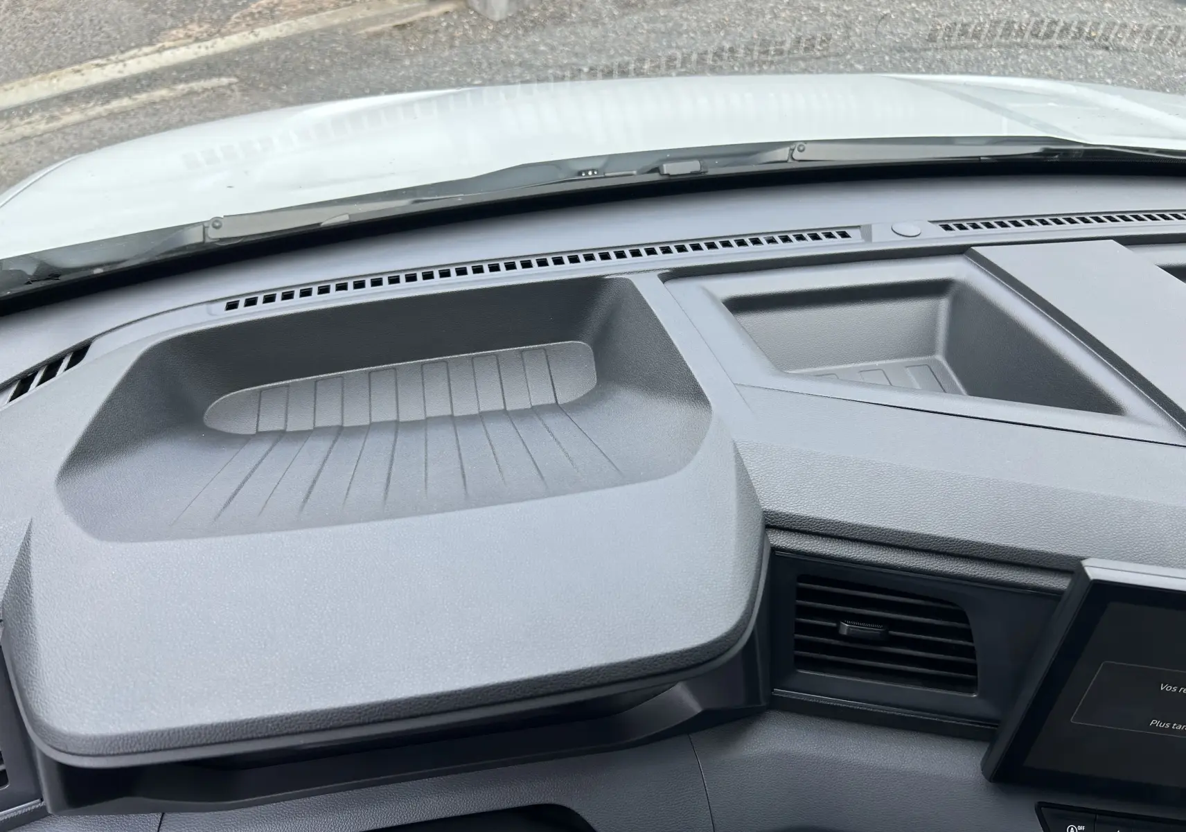 Vue rapprochée du tableau de bord gris foncé du Renault Master 2025, mettant en valeur les rangements intégrés.