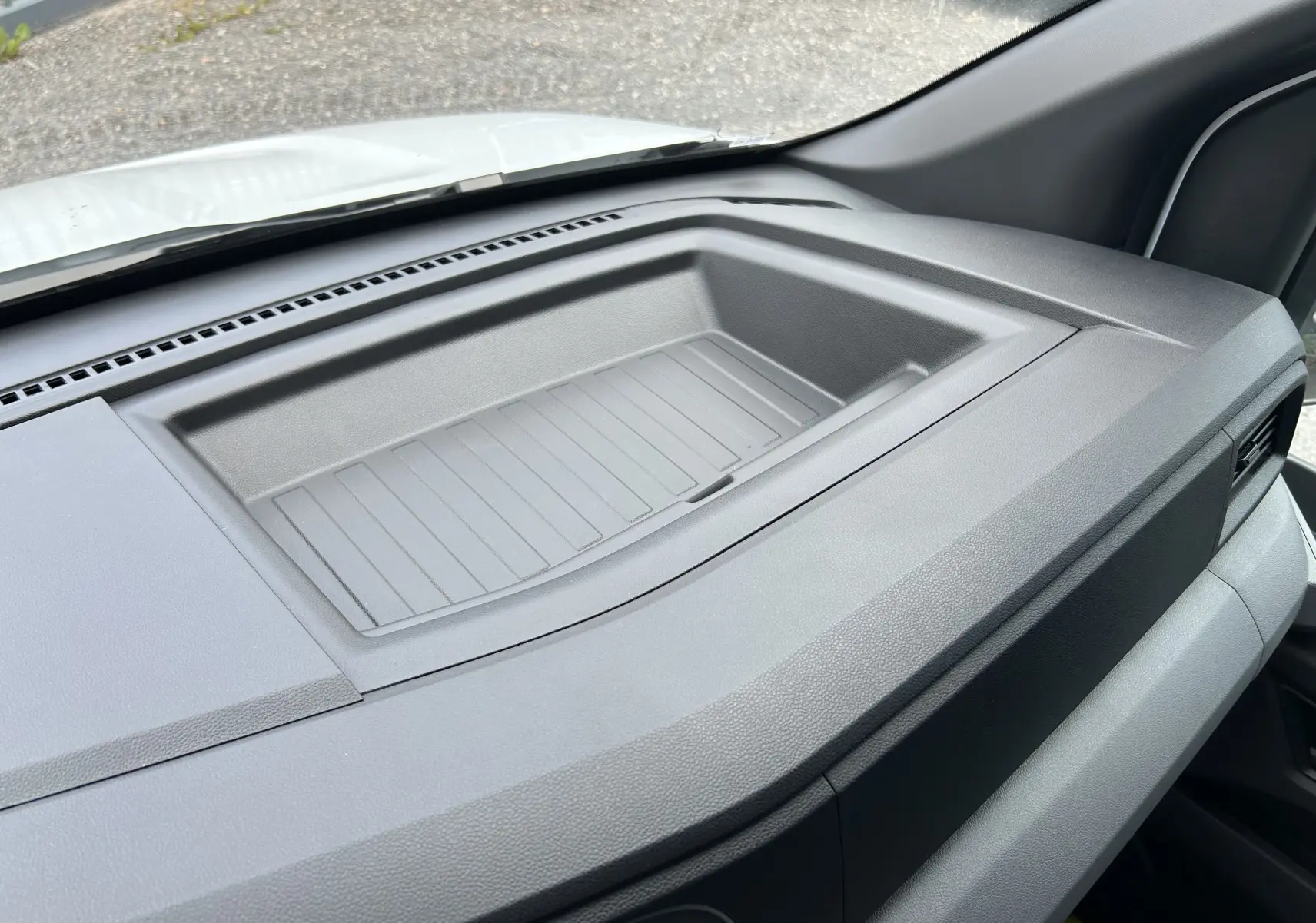 Vue intérieure du tableau de bord gris du Renault Master 2025, mettant en valeur un espace de rangement intégré.