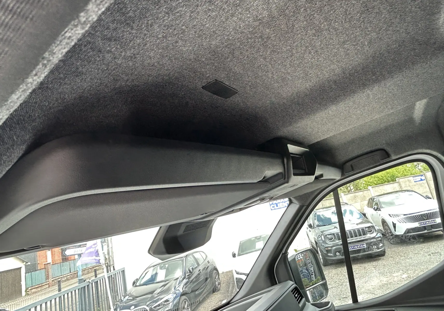 Vue intérieure côté droit du coffre de pavillon noir dans un Renault Master blanc, avec vue partielle sur l'extérieur.