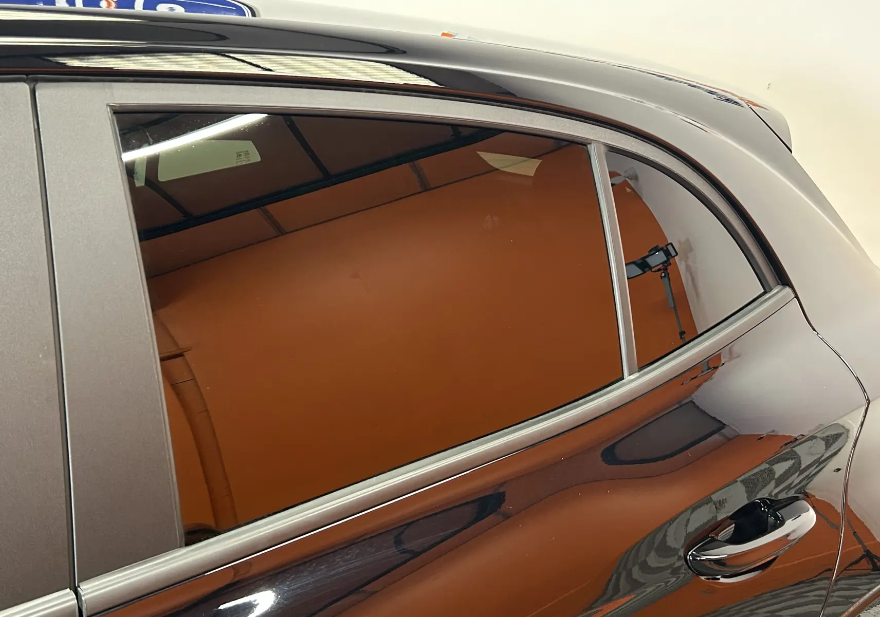 Vue rapprochée du côté gauche arrière de la MG3 Hybrid+ 195 Luxury Pebble Black avec vitre teintée et poignée chromée.