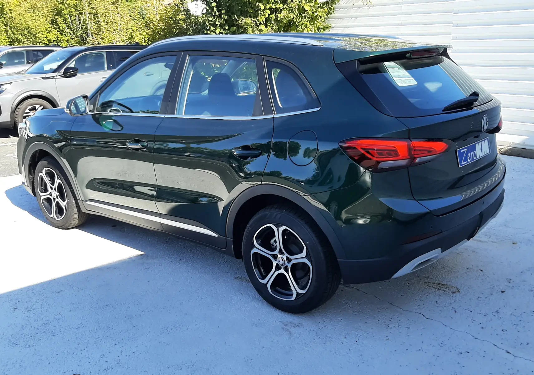 Vue 3/4 arrière droite d’un MG ZS Emerald Green hybride, avec jantes alliage et feux arrière LED distinctifs.