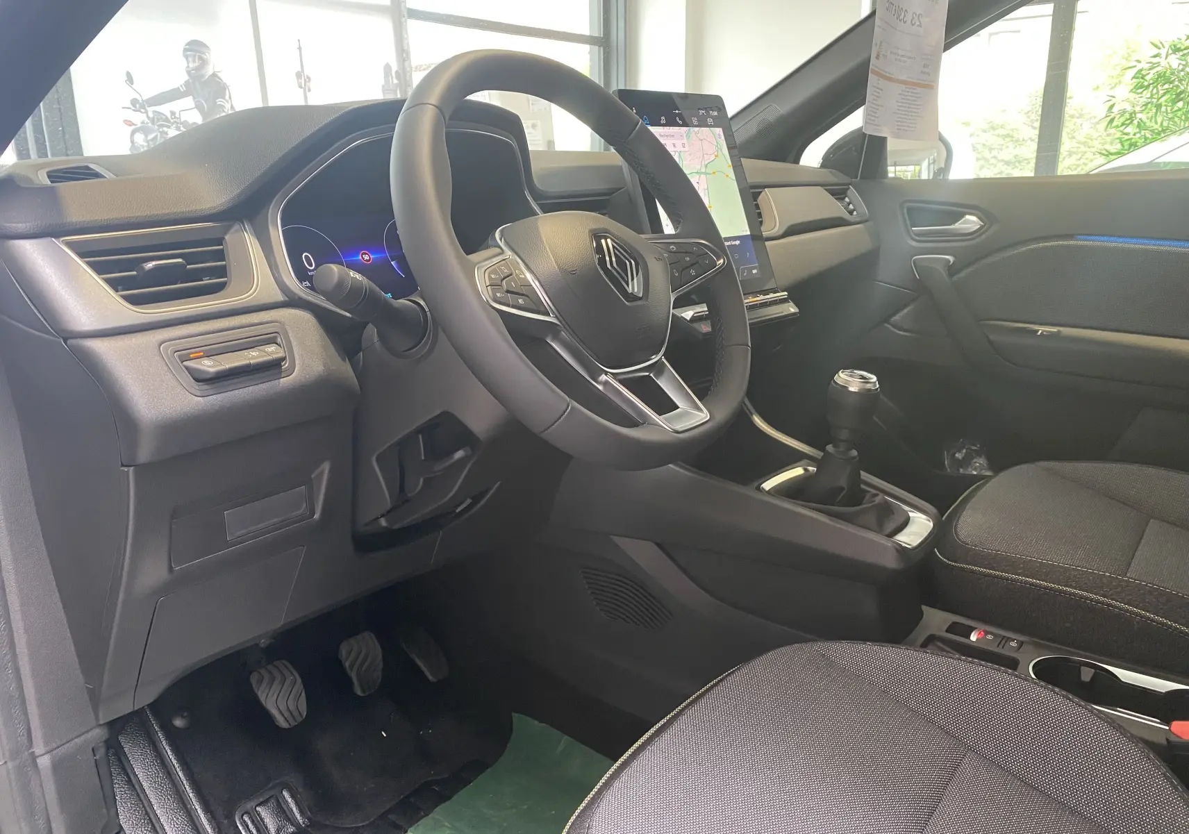 Intérieur du Renault Captur II 2024 vu côté conducteur, volant multifonction, écran tactile vertical et levier de vitesse manuel.