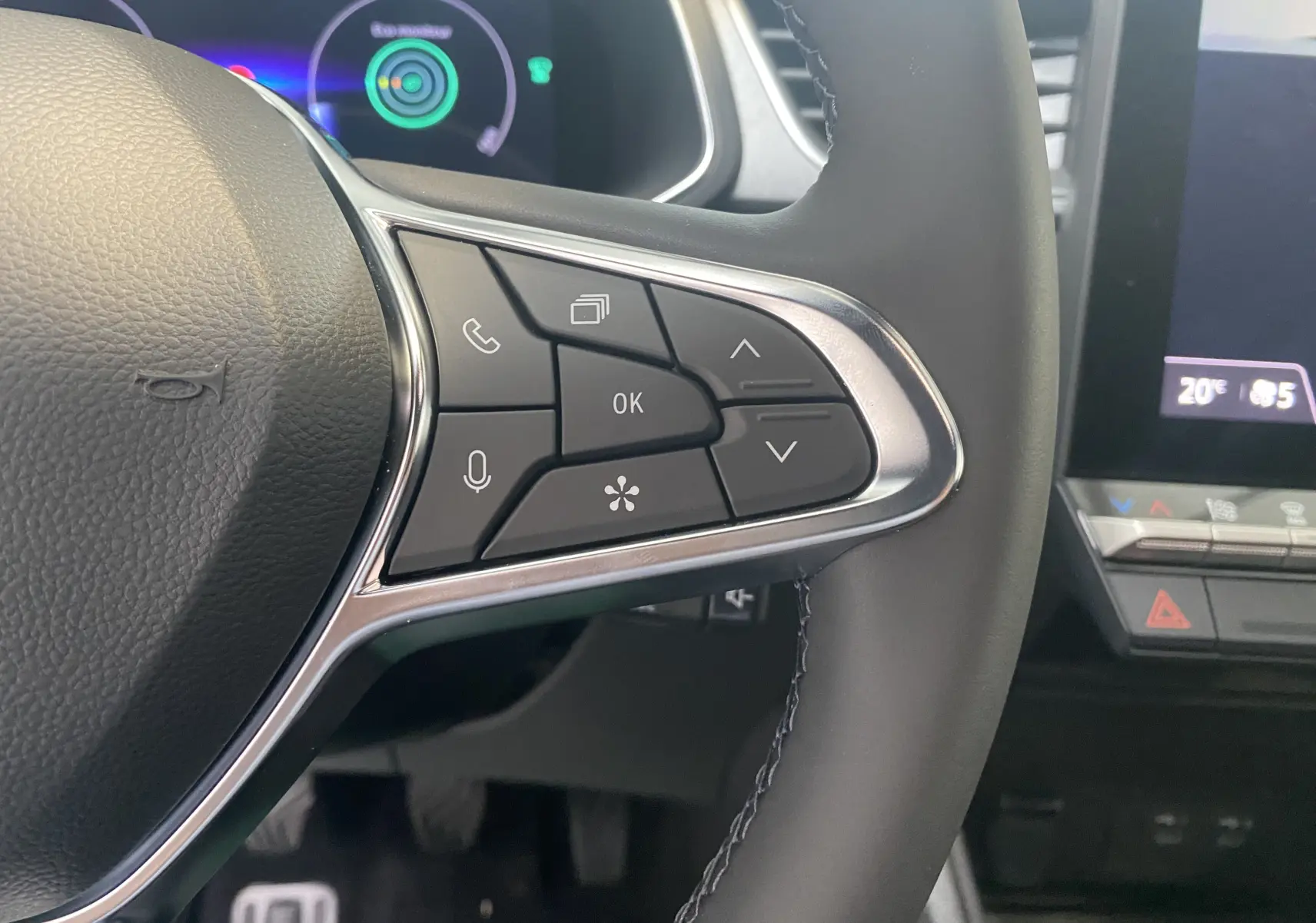 Gros plan sur les commandes à droite du volant du Renault Captur gris zinc métal 2024, avec écran digital en arrière-plan.