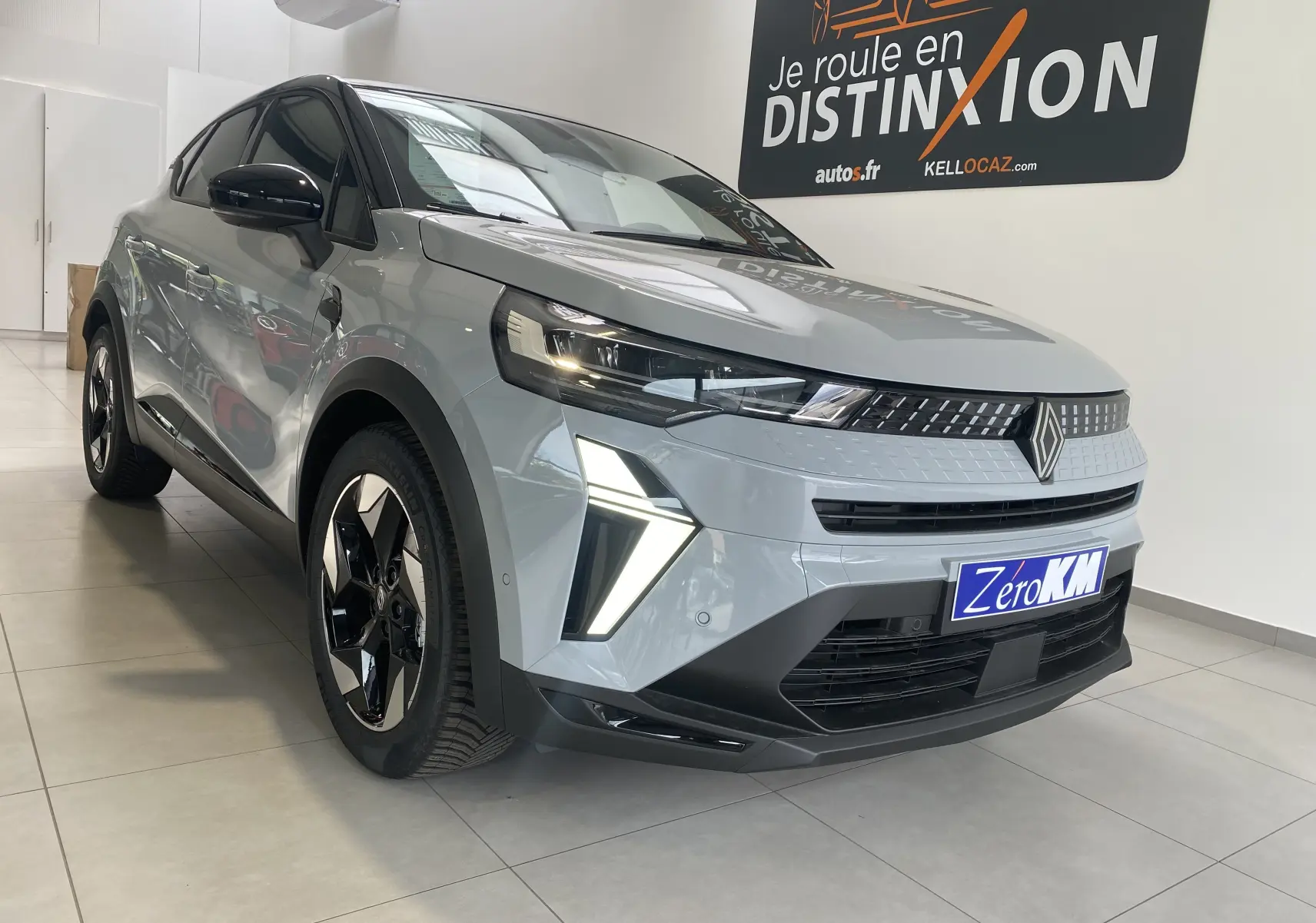 Renault Captur II gris zinc métal vu en 3/4 avant droit, avec feux LED allumés et jantes biton 18 pouces.