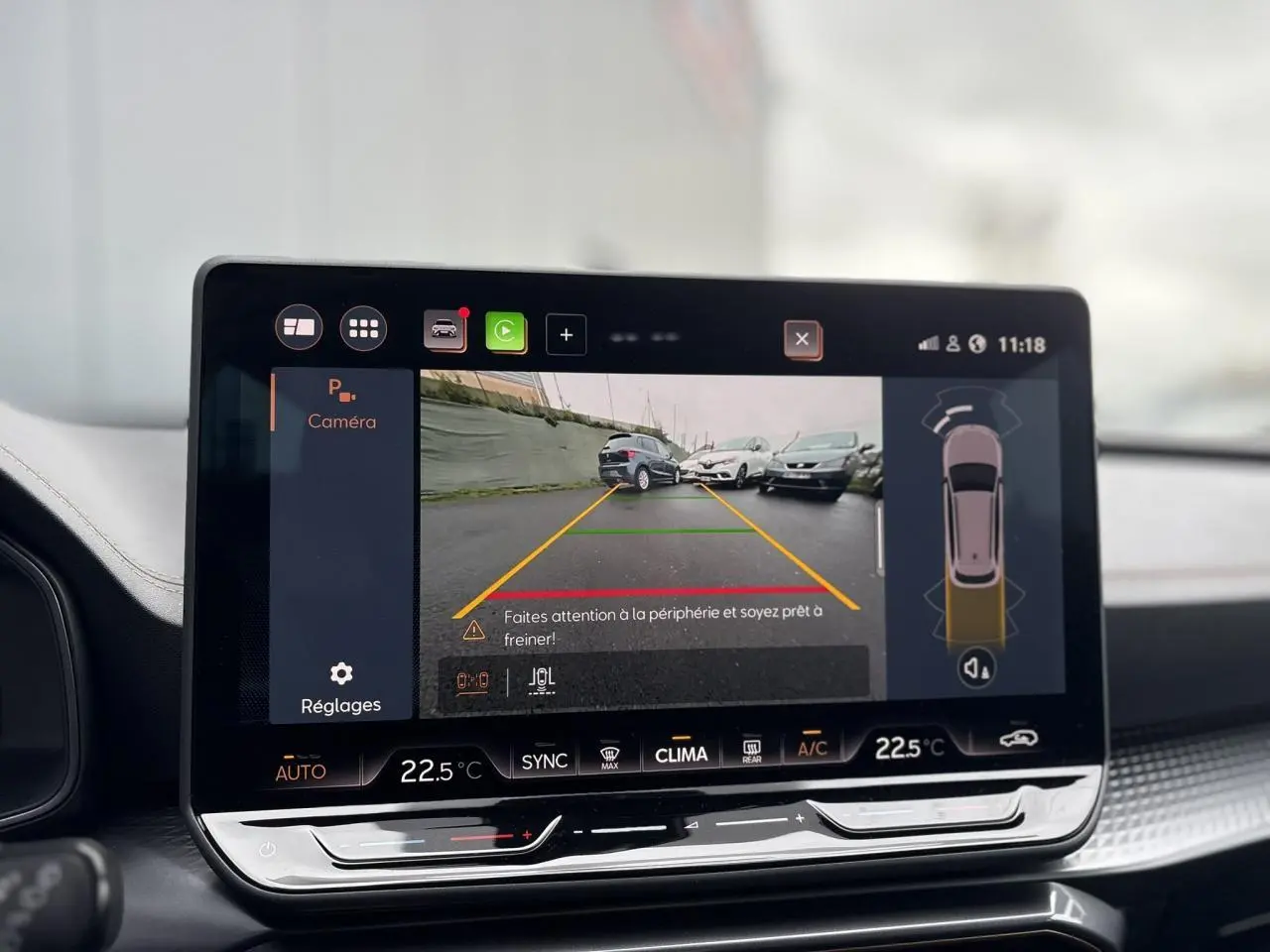 Écran tactile intérieur du CUPRA LEON ST 2025 montrant la caméra de recul avec lignes de guidage et vue périphérique.