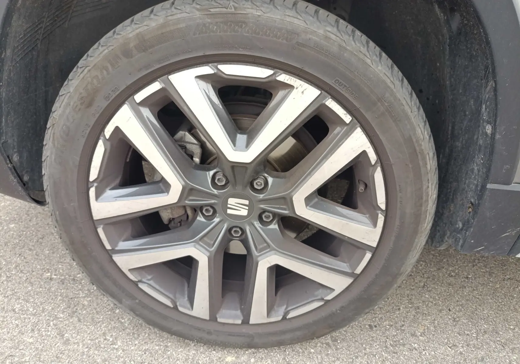 Gros plan sur la jante alliage 18 pouces du SEAT Ateca gris foncé, montrant le logo central et le pneu.