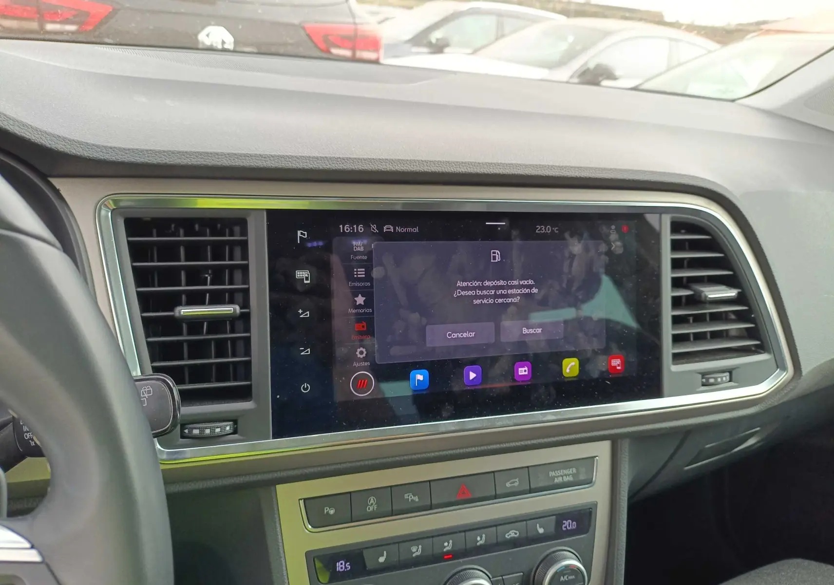 Vue intérieure du tableau de bord du SEAT Ateca 2023, écran tactile central avec commandes climatisation et aérateurs noirs.