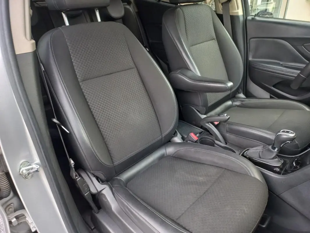 Vue intérieure rapprochée des sièges avant en tissu noir du côté gauche de l’Opel Mokka X gris 2017.