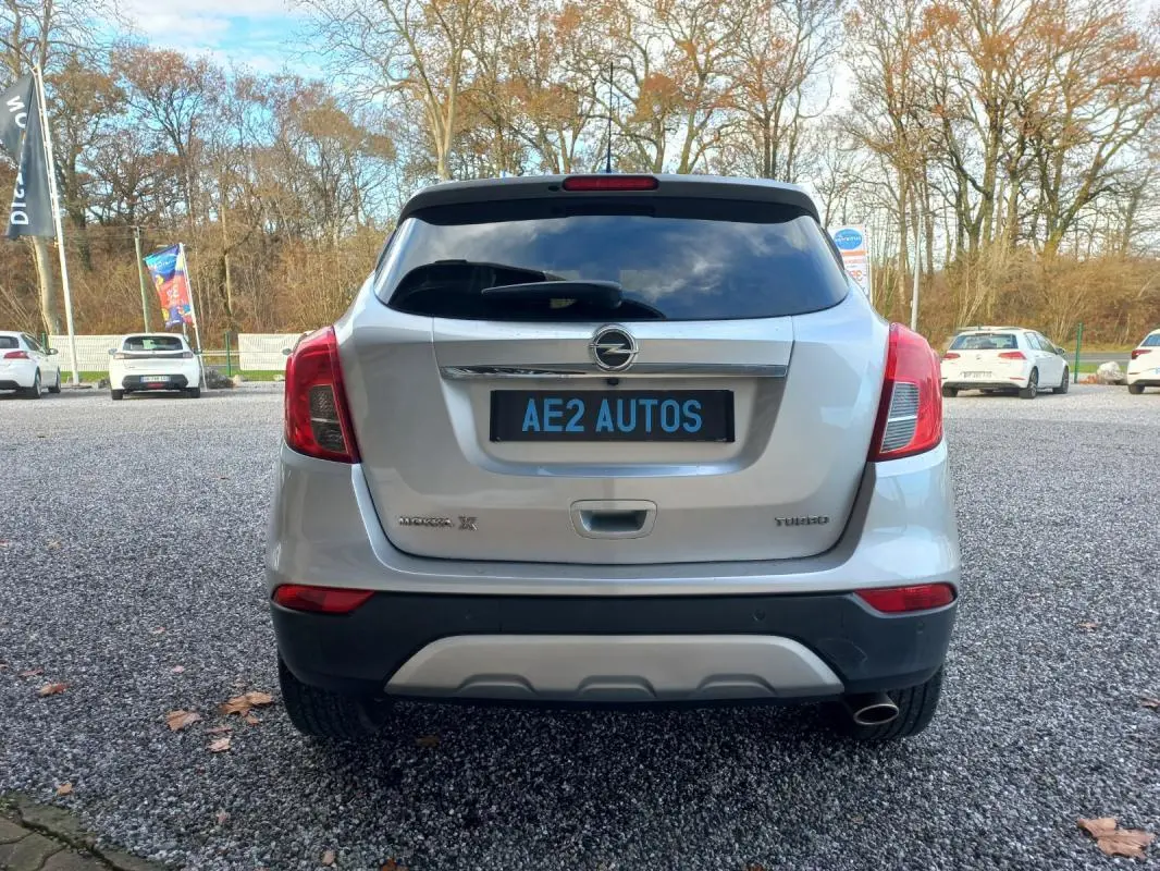 Vue arrière d'un Opel Mokka X gris 2017 avec logo Opel et badges Mokka X et Turbo visibles sur le coffre.