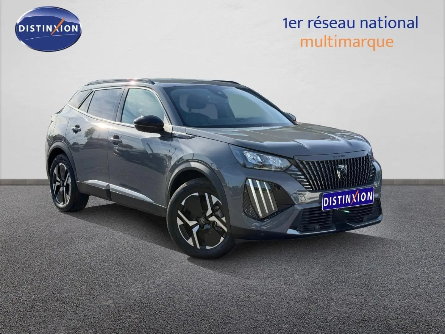 Peugeot e-2008 gris Artense vue 3/4 avant droit avec jantes alu et barres de toit visibles.