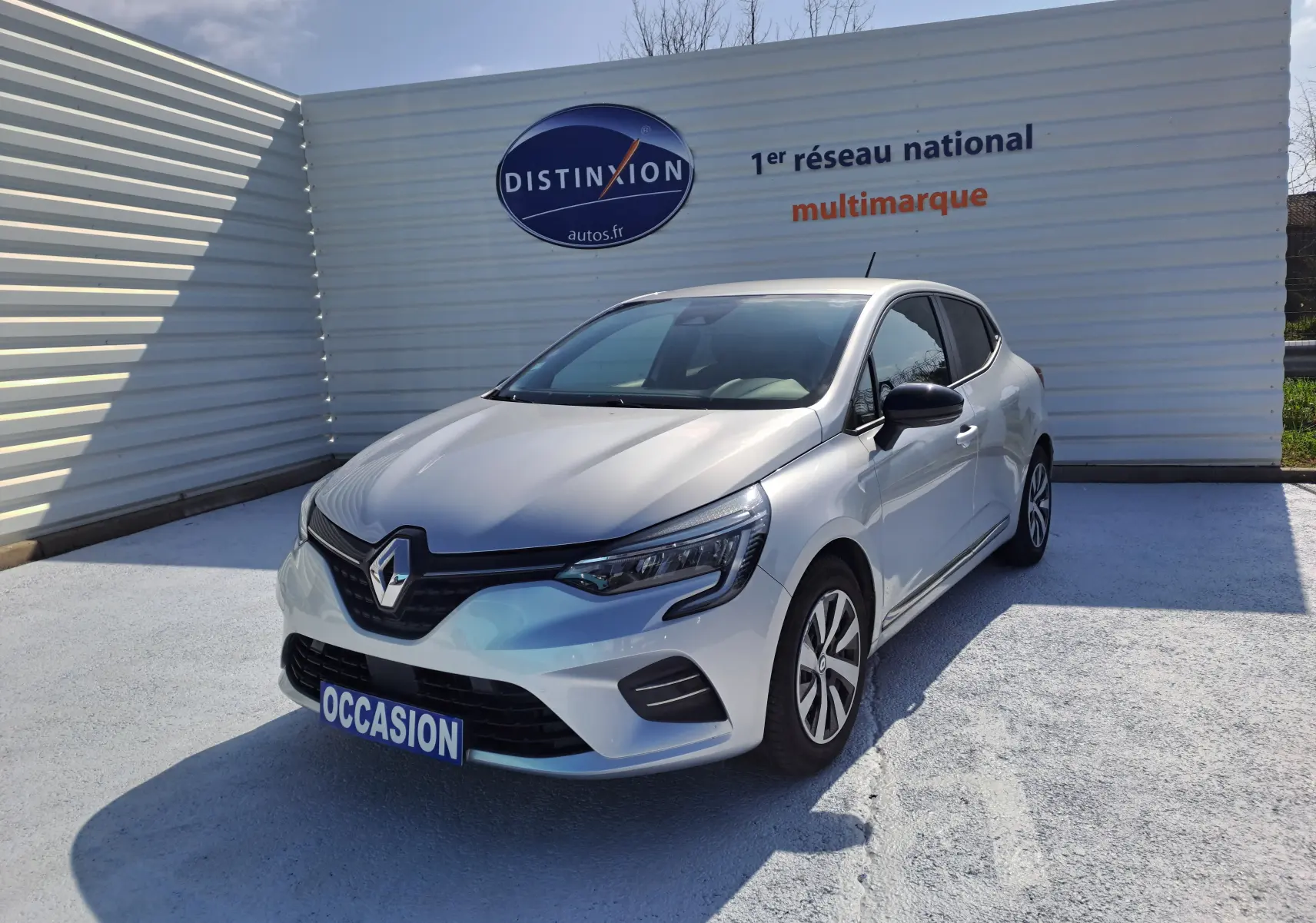 Renault Clio V gris Highland Metal vue 3/4 avant droit, avec calandre noire et feux LED modernes.