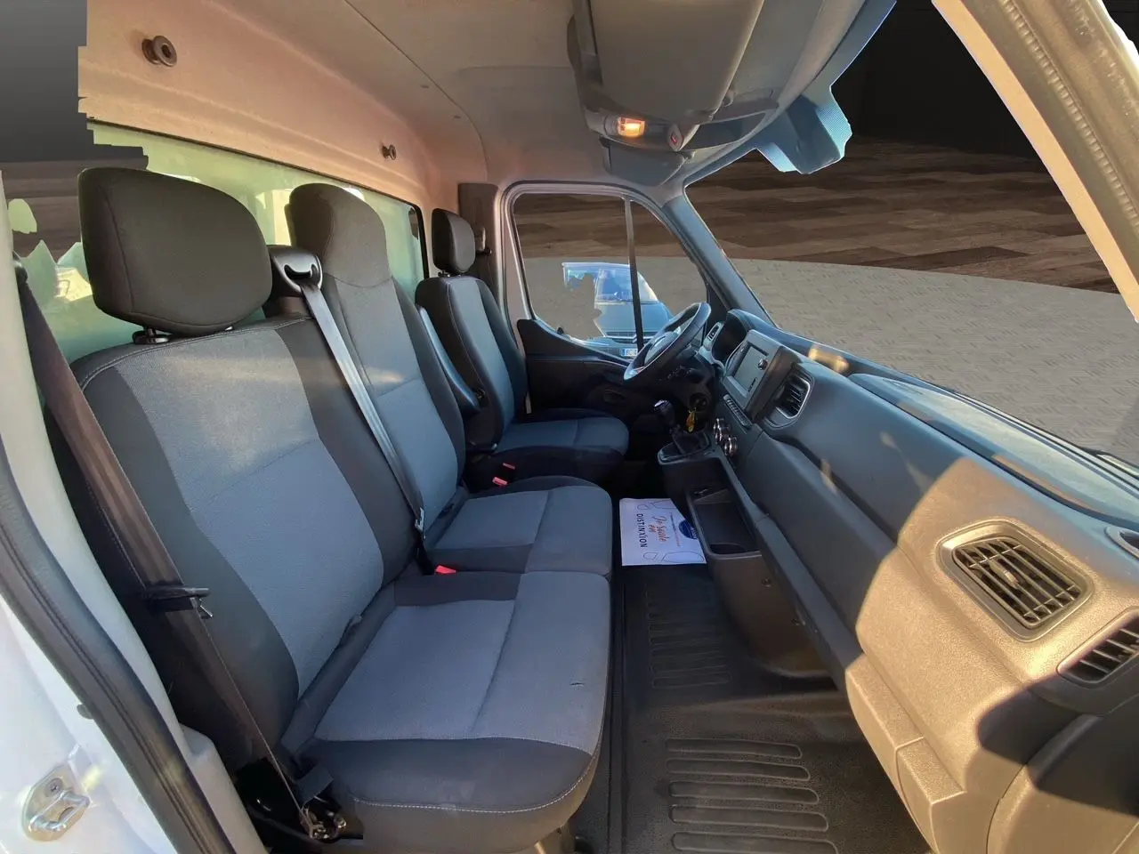 Intérieur du Renault Master Châssis Cabine 2023 vu côté gauche, sièges tissu noir et gris, tableau de bord fonctionnel.