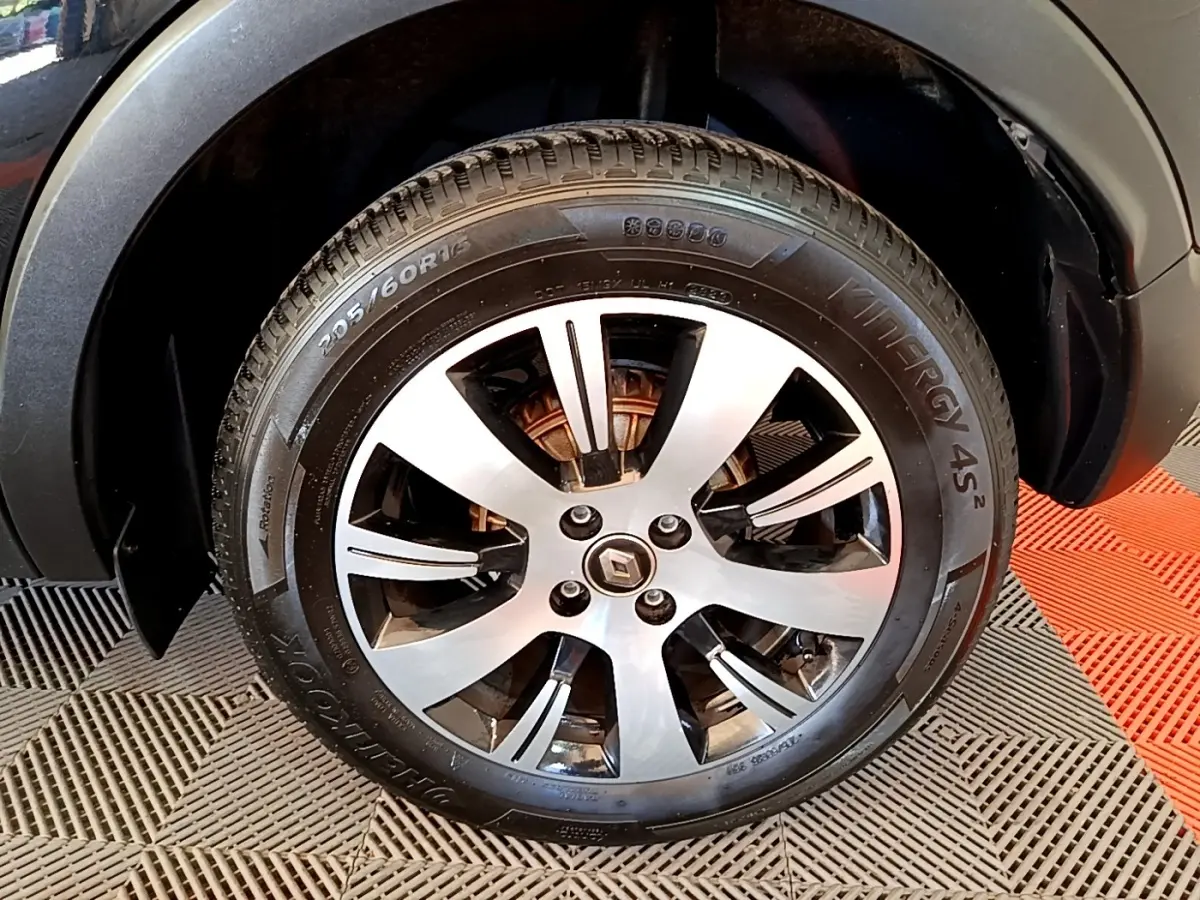 Gros plan sur la roue avant droite du Renault Captur noir, mettant en valeur la jante alliage et le logo central Renault.