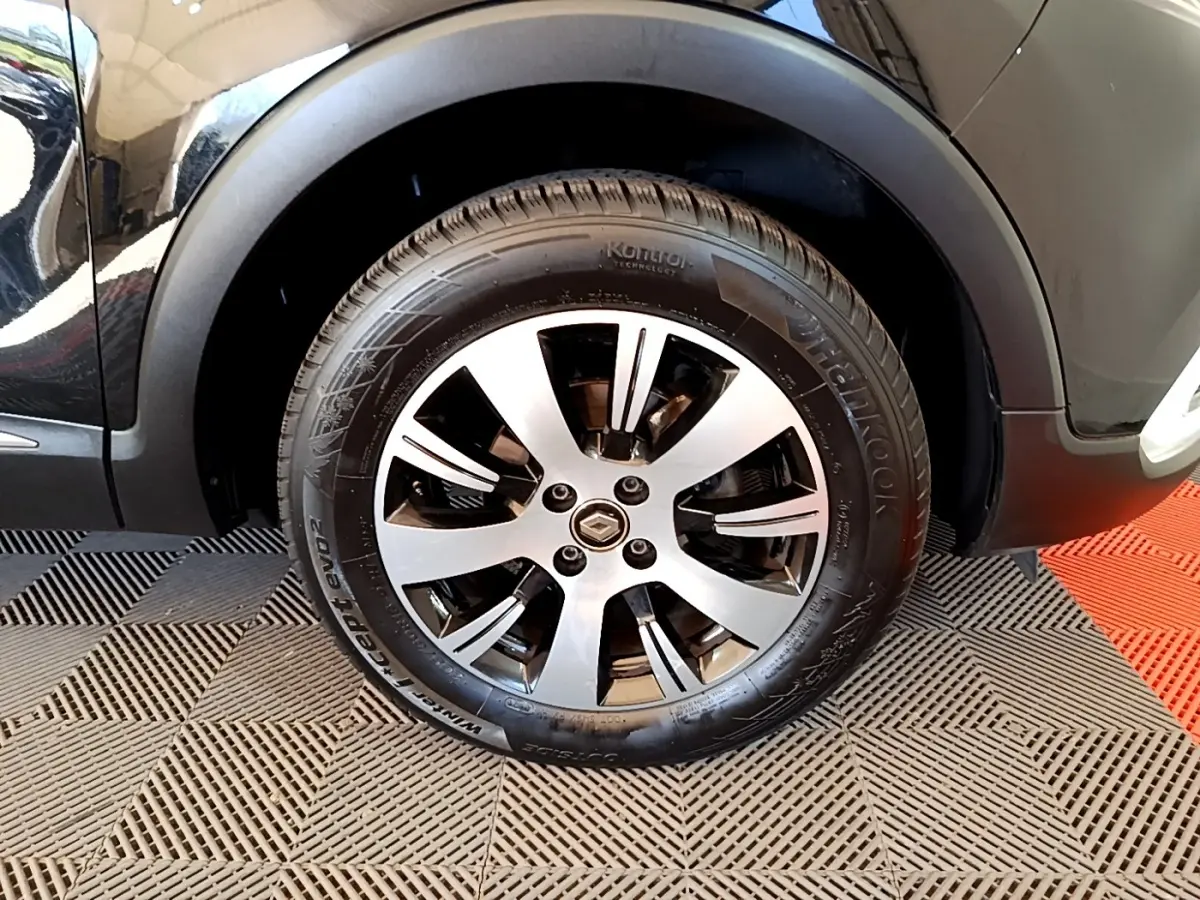 Gros plan sur la roue avant droite noire du Renault Captur Business TCe 90 de 2018 avec jante alliage.