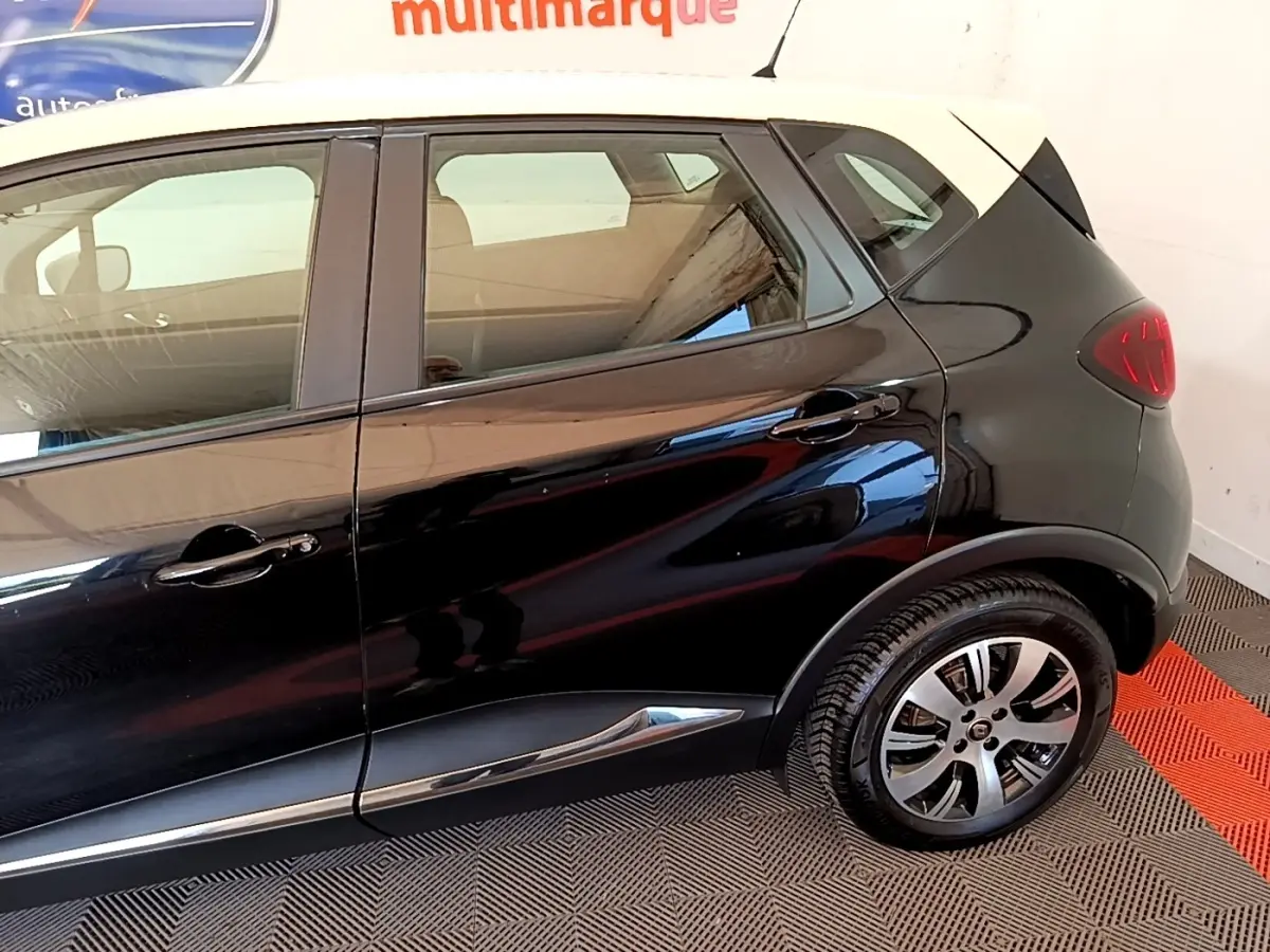 Vue latérale droite du Renault Captur noir avec toit blanc, soulignant les jantes alliage et les poignées de porte noires.