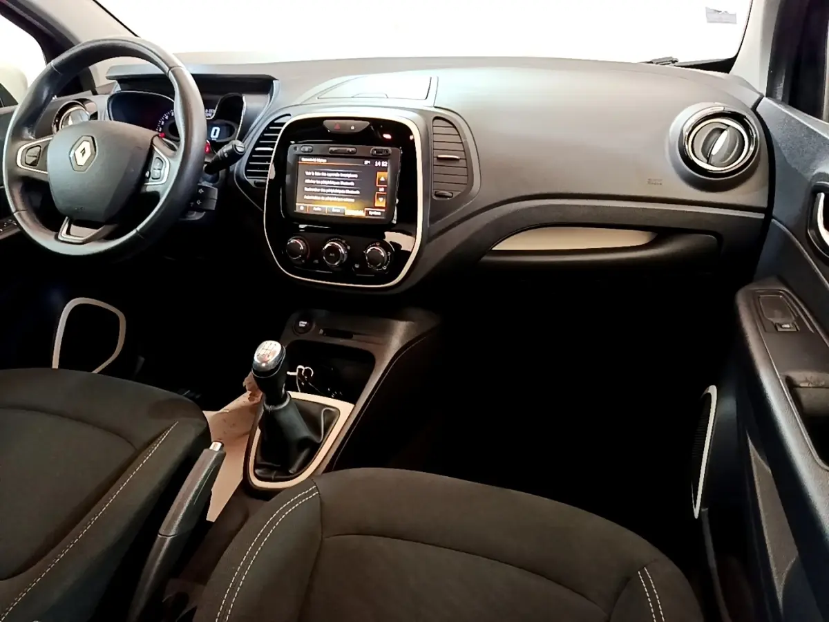 Vue intérieure avant du Renault Captur Business TCe 90 2018 noir, avec tableau de bord tactile et boîte manuelle.