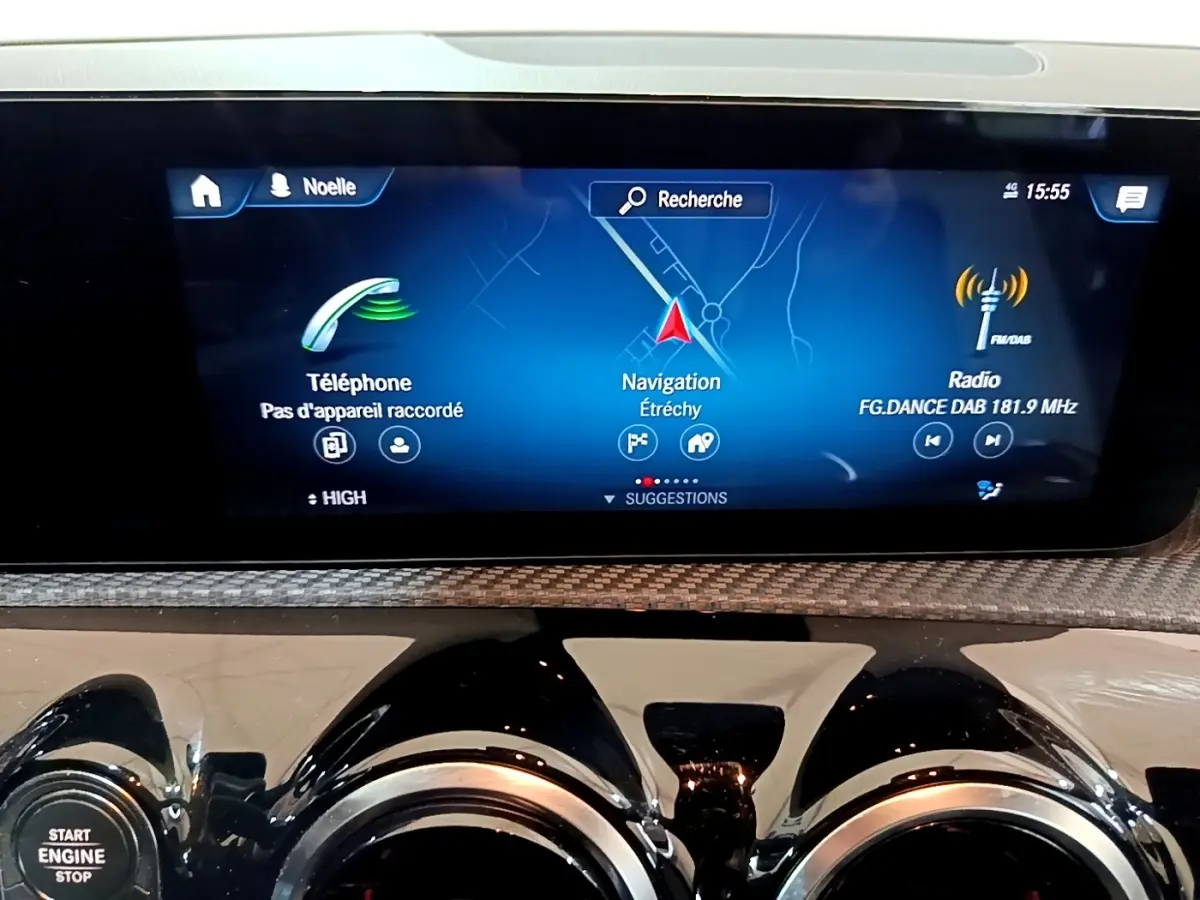 Écran tactile central affichant navigation, téléphone et radio dans une Mercedes Classe A blanche, vue intérieure avant.