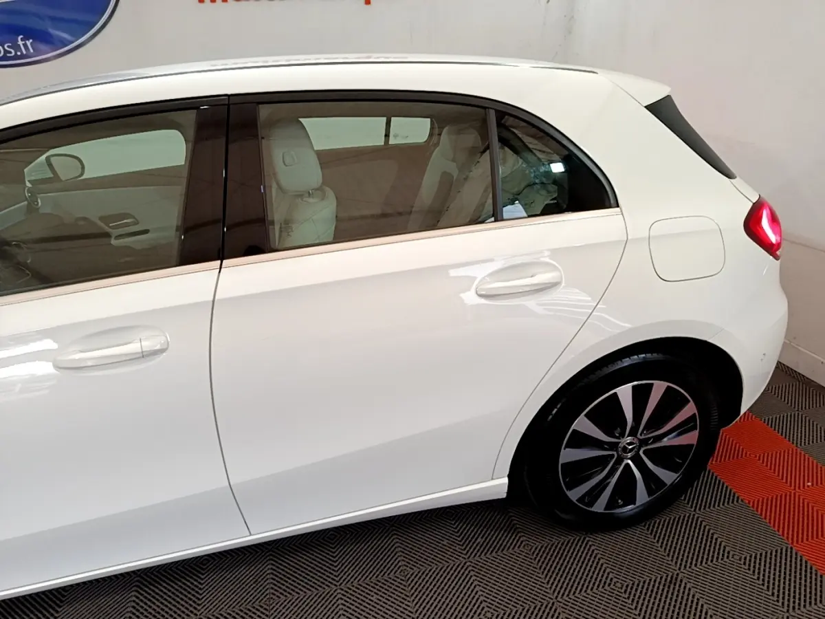 Vue latérale droite d'une Mercedes Classe A Berline A 250 e Business Line blanche, avec jantes alliage et vitres teintées.