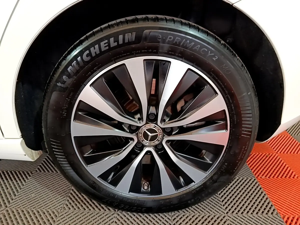 Gros plan sur la roue avant droite d’une Mercedes Classe A blanche, jante alliage bicolore et pneu Michelin.