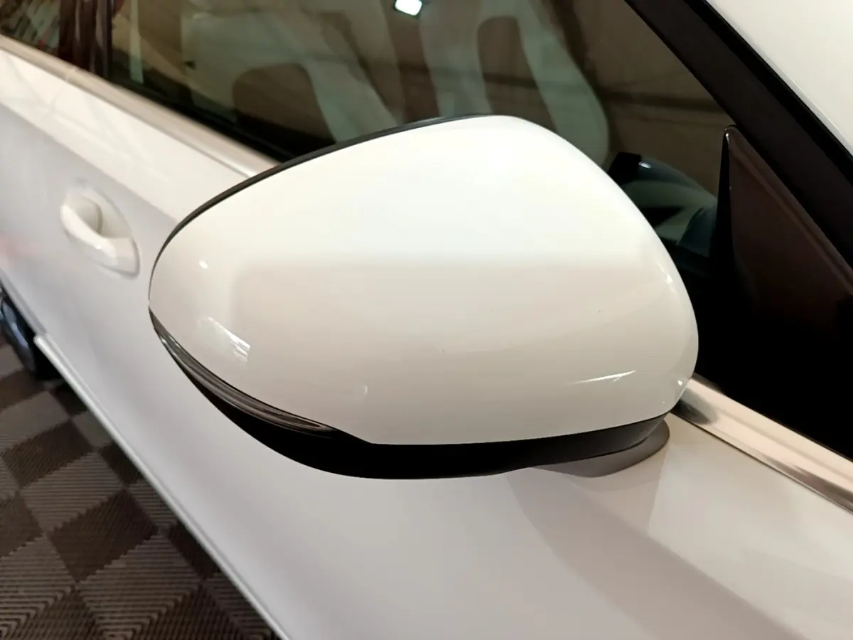 Gros plan sur le rétroviseur droit blanc de la Mercedes Classe A Berline A 250 e Business Line 2020.