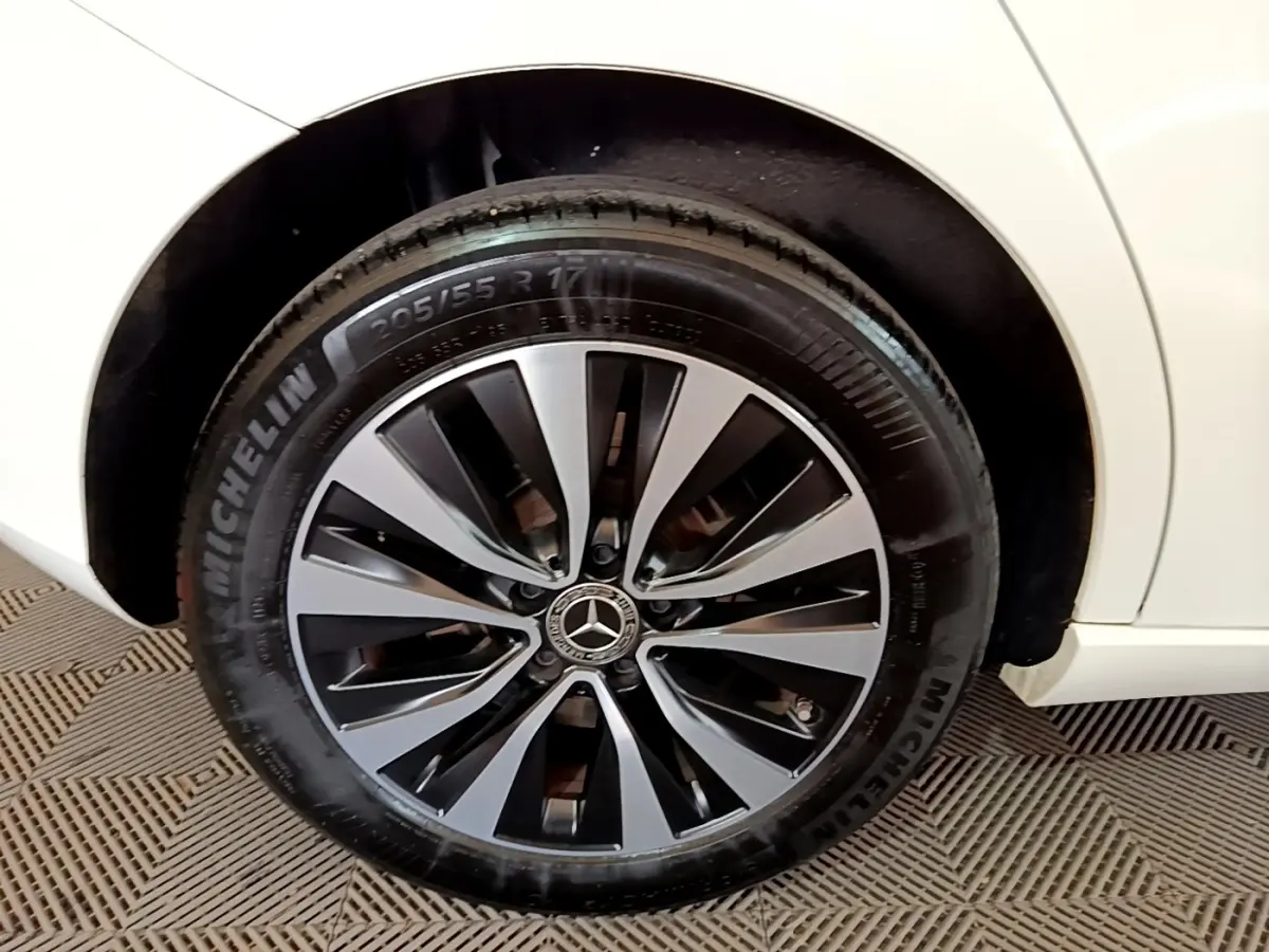 Gros plan sur la roue arrière droite d'une Mercedes Classe A blanche, jante alliage noir et argent avec pneu Michelin.