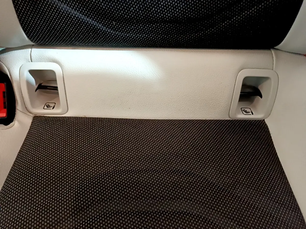 Gros plan sur la banquette arrière en tissu gris foncé avec appuie-têtes et ceintures intégrées d'une Mercedes Classe A blanche.