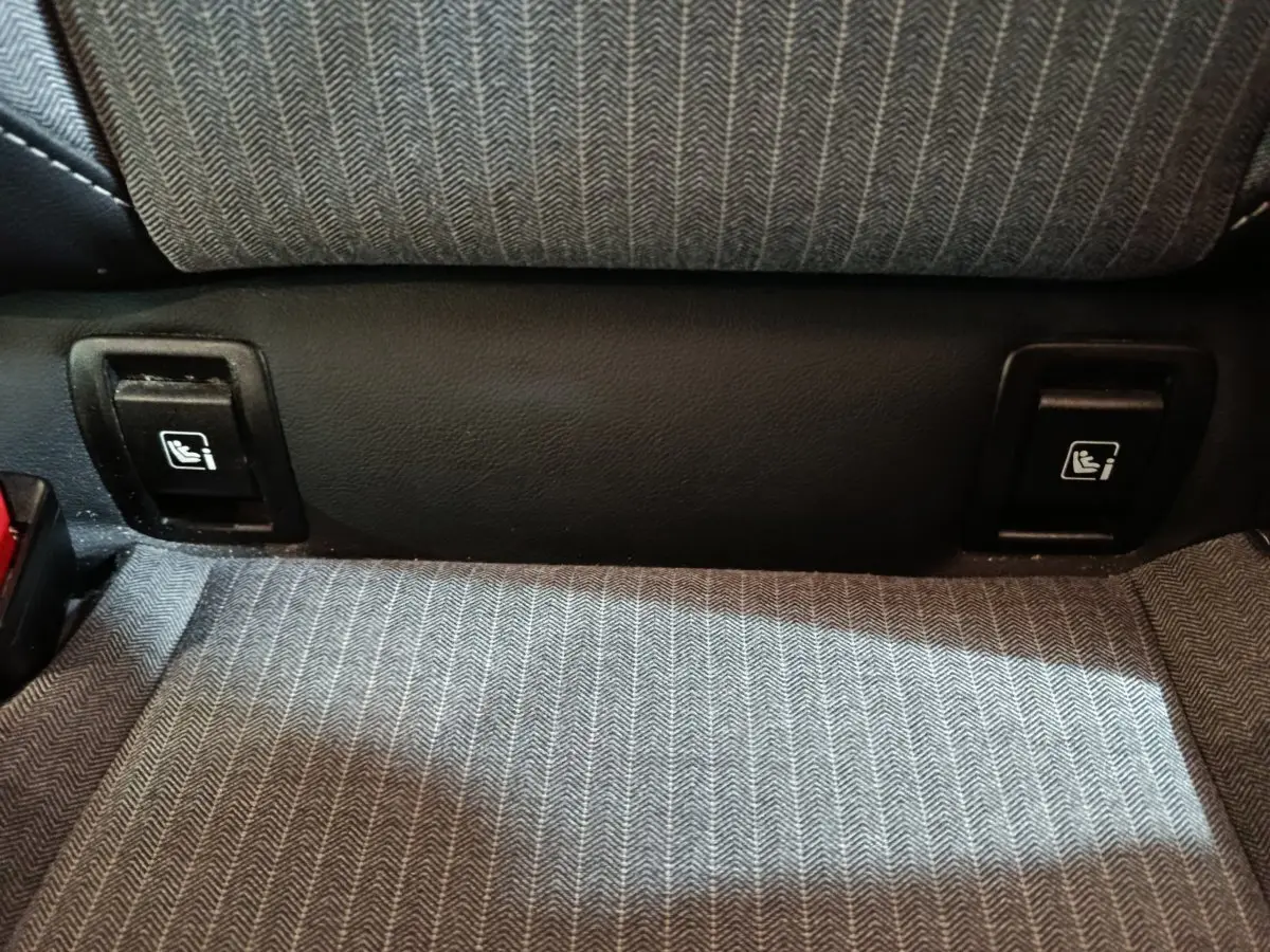 Détail des commandes Isofix sur la banquette arrière en tissu gris de la Renault Clio Techno TCe 90 2024.