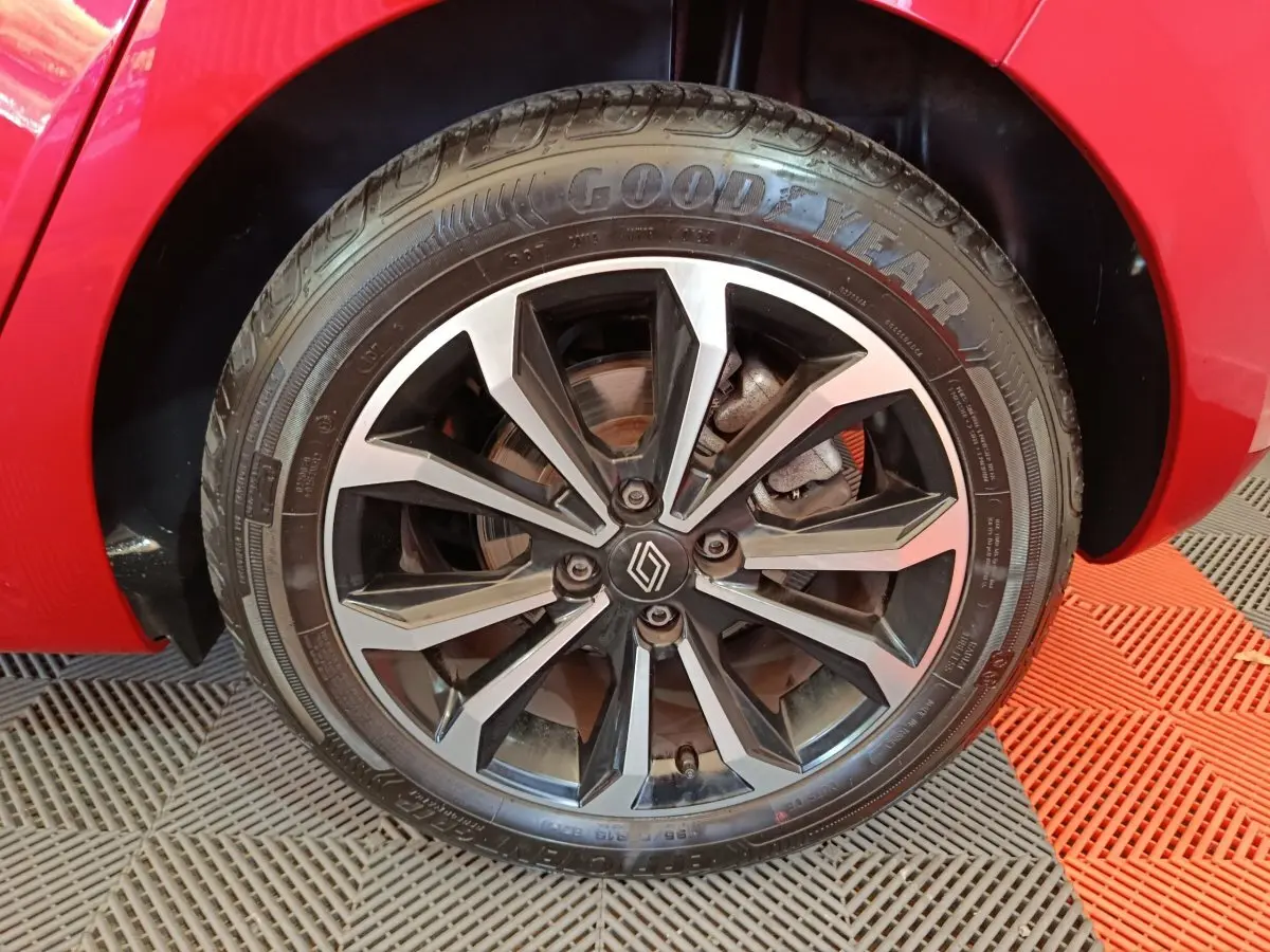 Gros plan sur la roue avant droite d’une Renault Clio rouge 2024 avec jante alliage noire et argentée au design moderne.