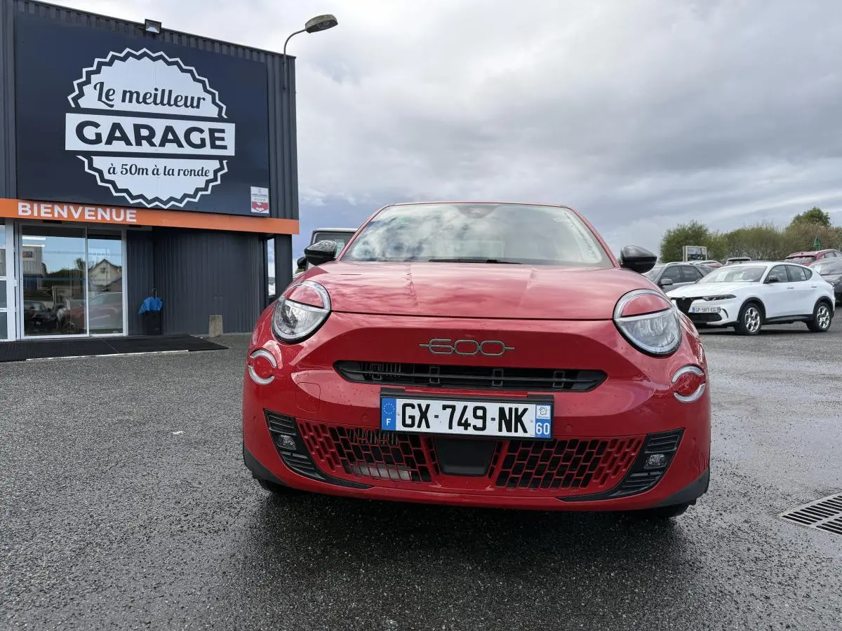 Vue frontale d'une FIAT 600 rouge 2024 avec logo chromé 600 sur la calandre et phares ronds distinctifs.