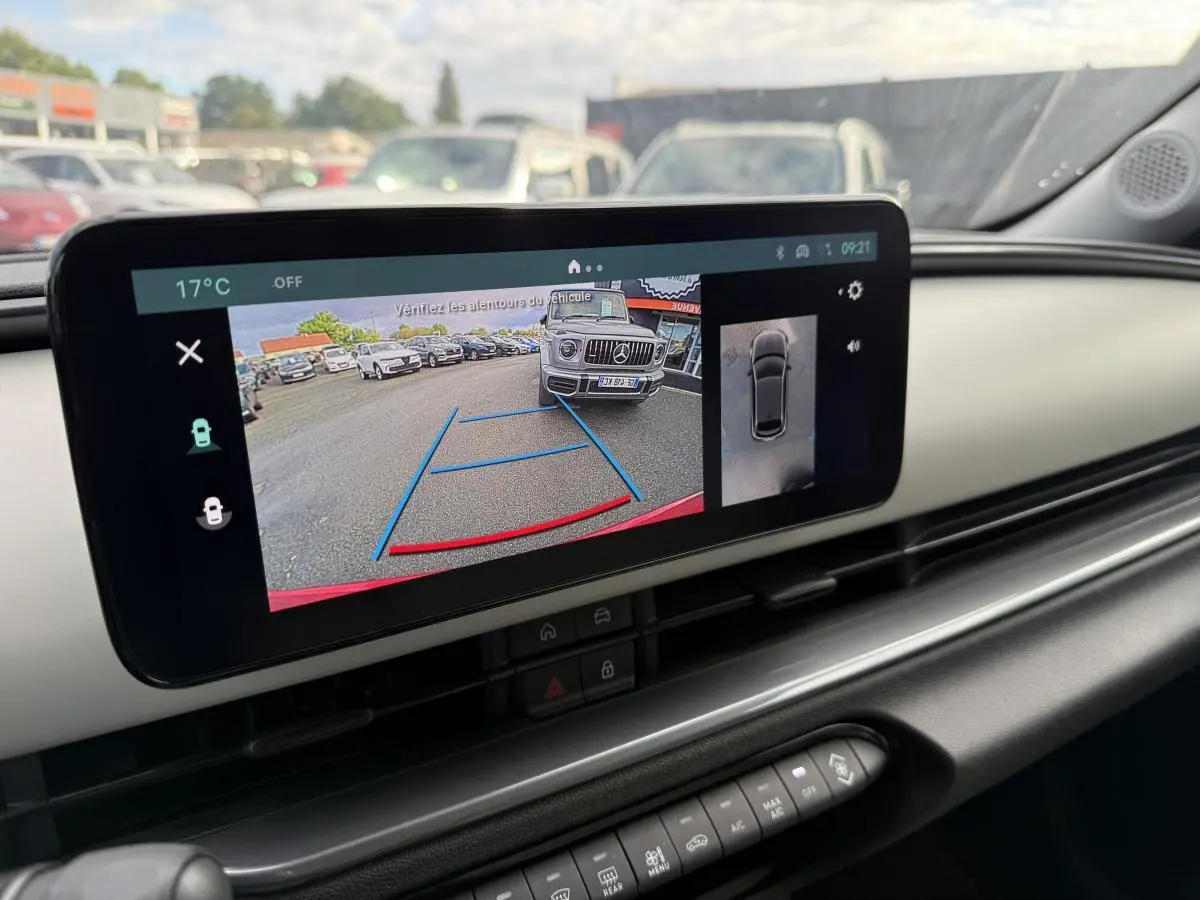 Vue intérieure du tableau de bord ivoire de la Fiat 600 La Prima 2024 avec écran affichant la caméra de recul en action.