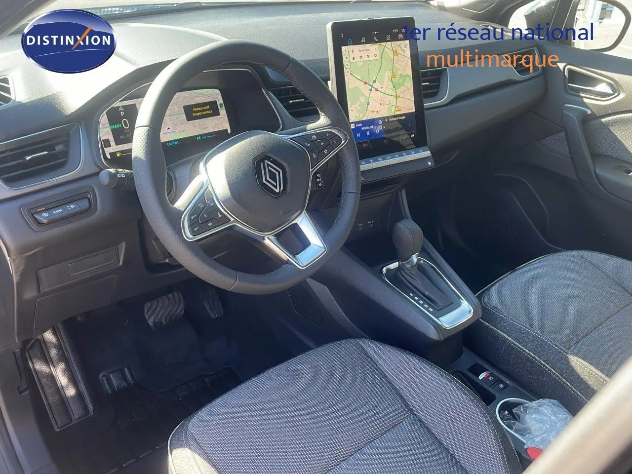 Intérieur Renault Captur E-Tech hybride 2025 vu côté conducteur, volant multifonction et écran tactile vertical.
