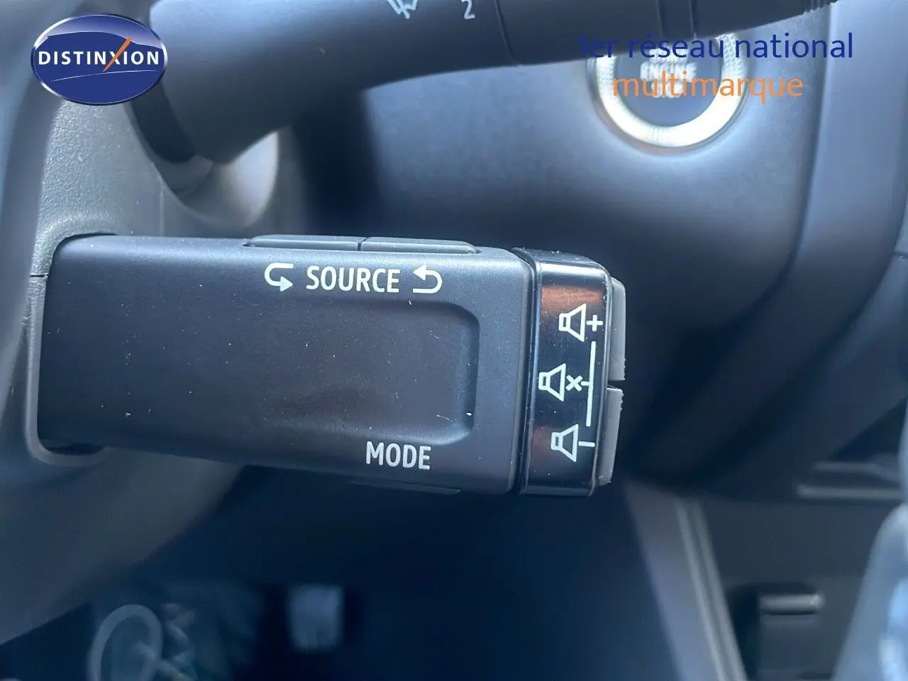 Commande au volant pour régler la source audio et le volume sur Renault Captur E-Tech Hybrid 2025, intérieur noir.