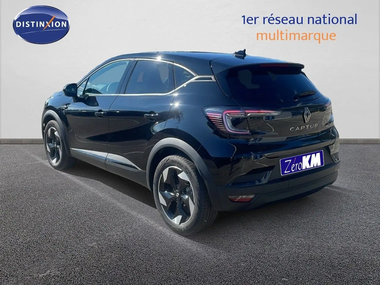 Vue 3/4 arrière droite d'un Renault Captur noir étoile métal 2025, hybride essence, avec jantes bi-ton et feux LED distinctifs.