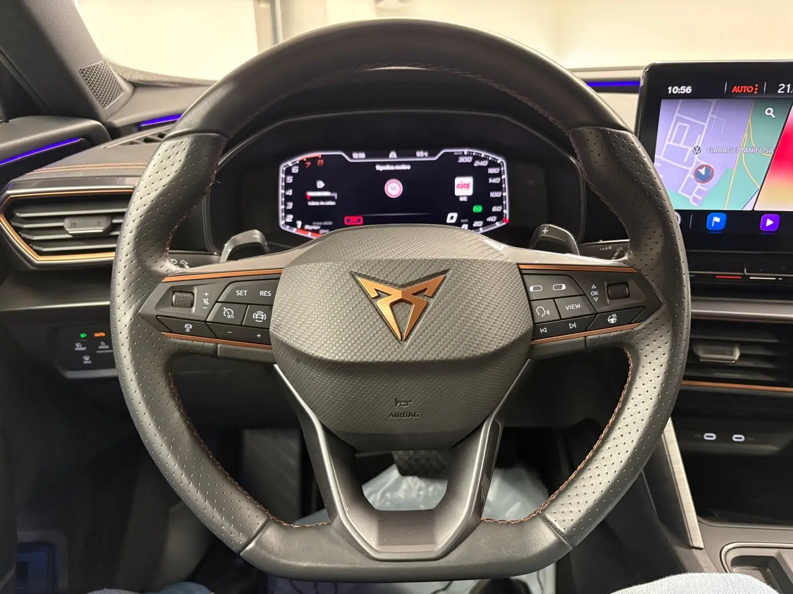 Vue rapprochée du volant noir perforé avec logo CUPRA cuivré et tableau de bord numérique du Formentor 2024.