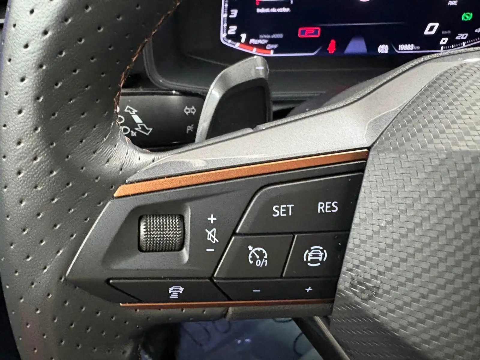 Gros plan sur les commandes gauche du volant perforé du CUPRA Formentor 2024, finition noire avec détails cuivrés.