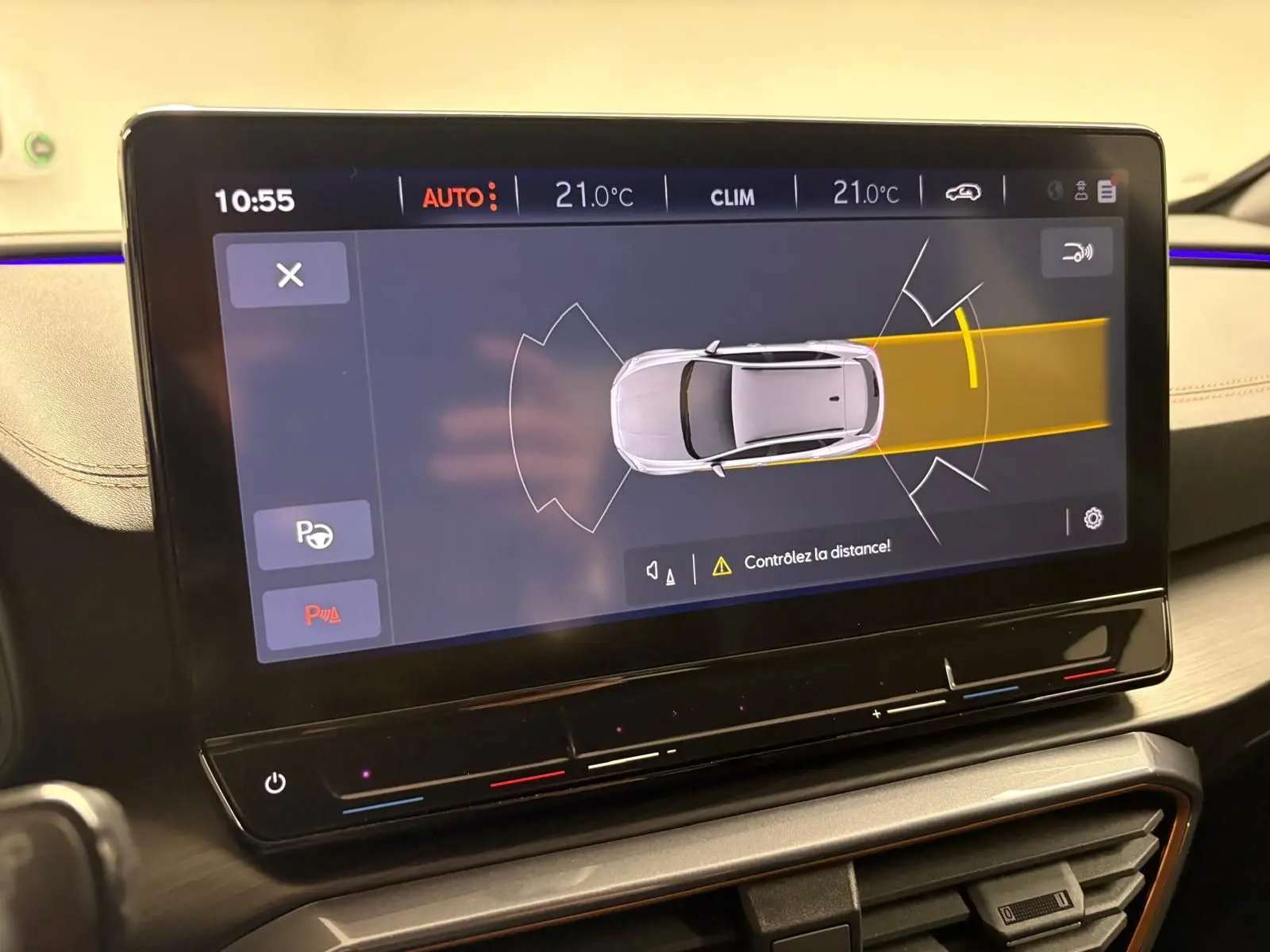 Écran tactile intérieur montrant l'assistance au stationnement avec vue aérienne du CUPRA Formentor 2024 en gris.