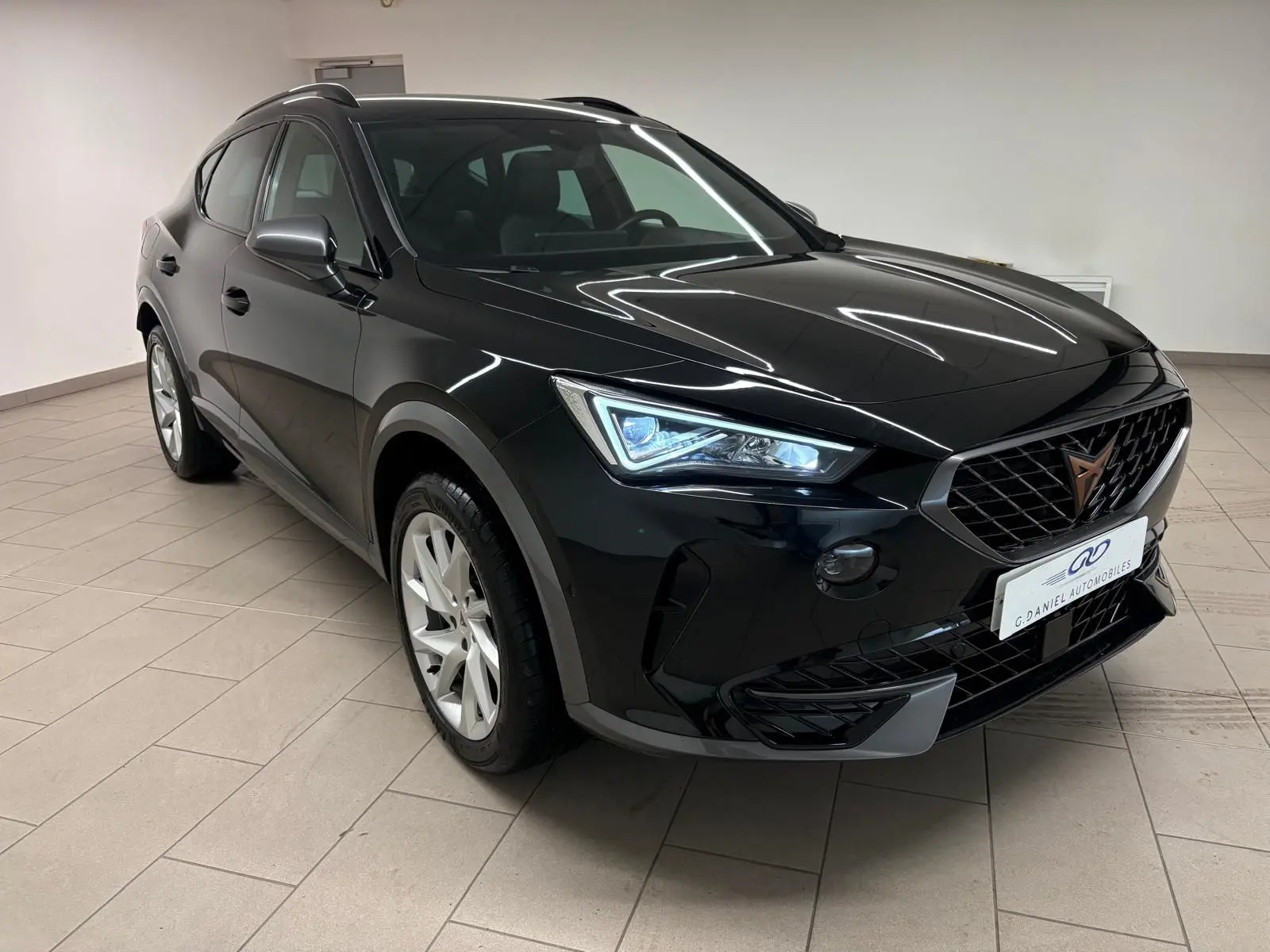 Vue 3/4 avant gauche du CUPRA Formentor 2024 noir minuit avec calandre distinctive et phares LED allumés.