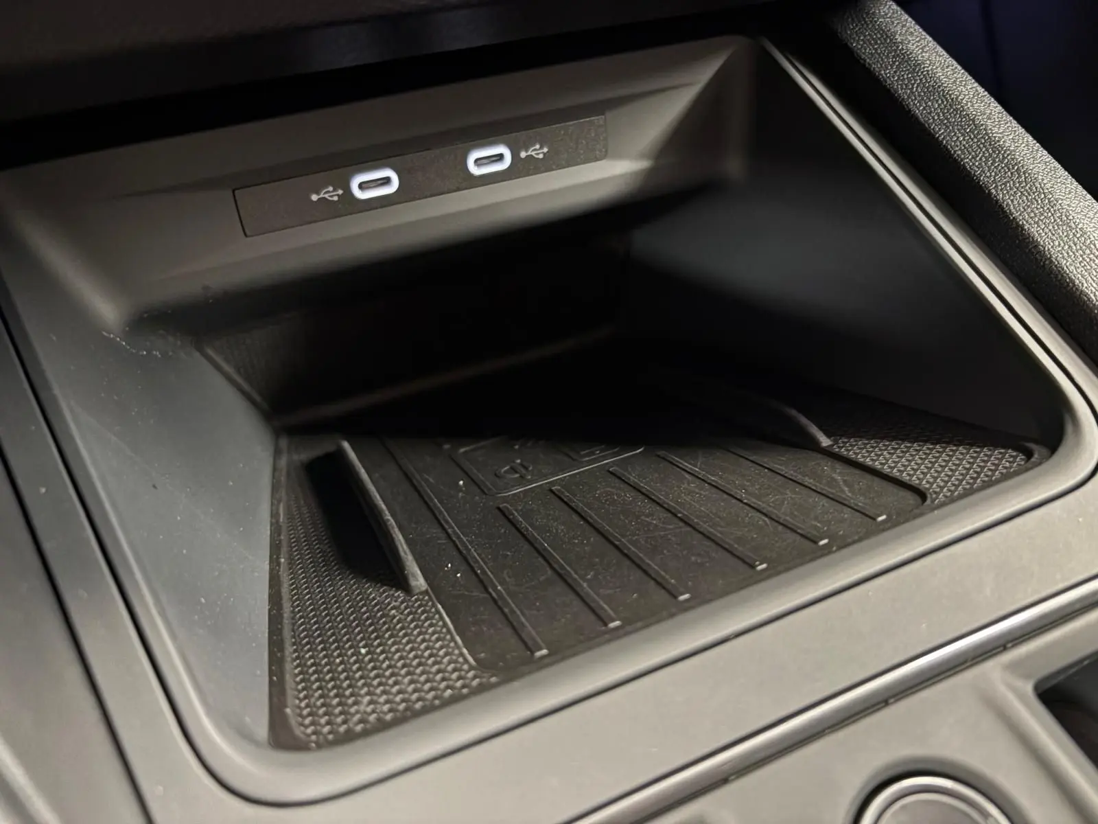 Gros plan sur le compartiment de recharge sans fil avec deux ports USB-C illuminés dans une CUPRA Formentor Noir Minuit.